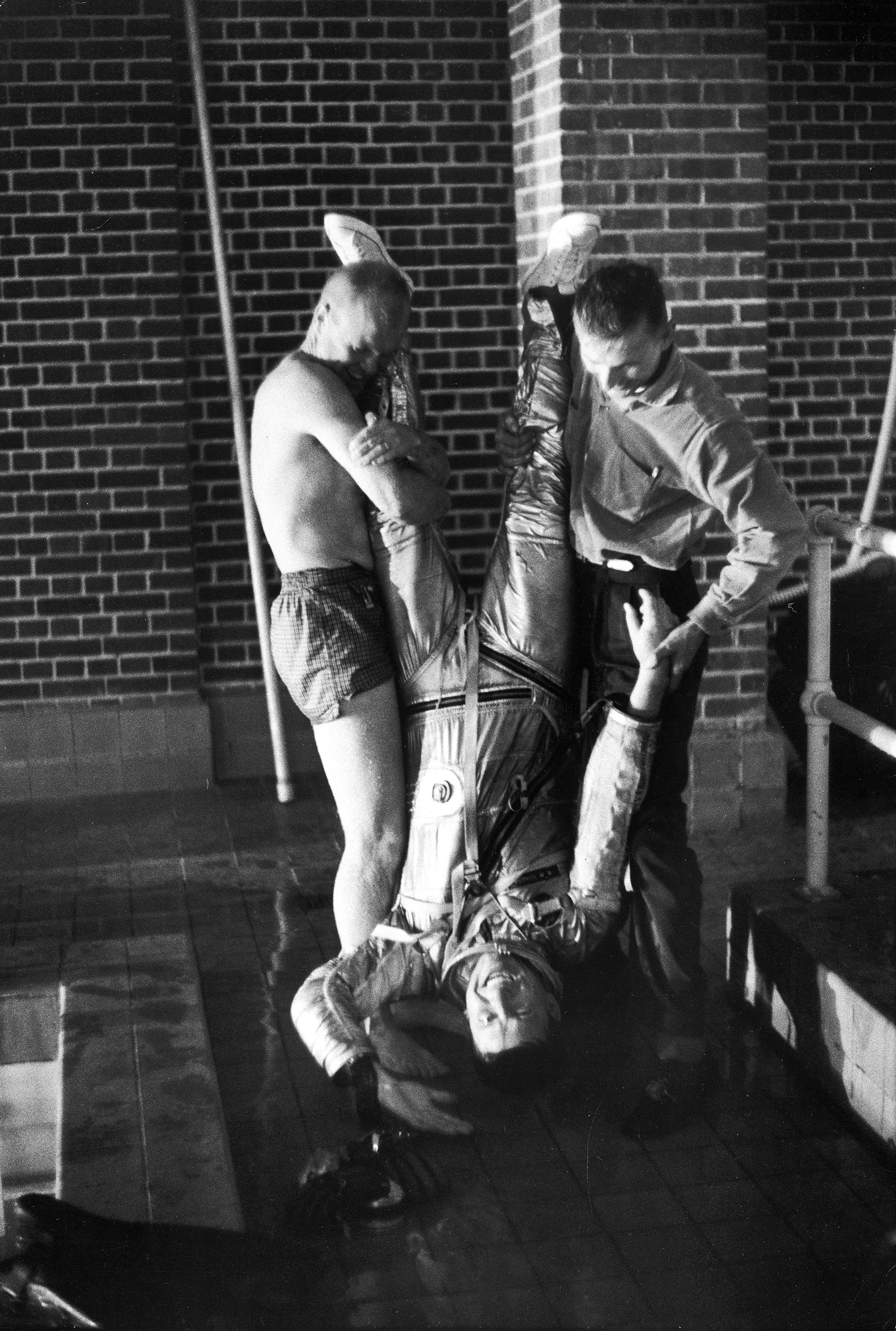 A Draining Training Session Glenn, left, and a NASA technician try a low-tech — but very direct — way of helping fellow astronaut Wally Schirra drain his pressure suit of water after testing it in a pool in 1960. Knowing the suit's flotation properties may have helped save the life of Gus Grissom, who wound up paddling in the Atlantic Ocean after the hatch of his spacecraft blew off following splashdown.