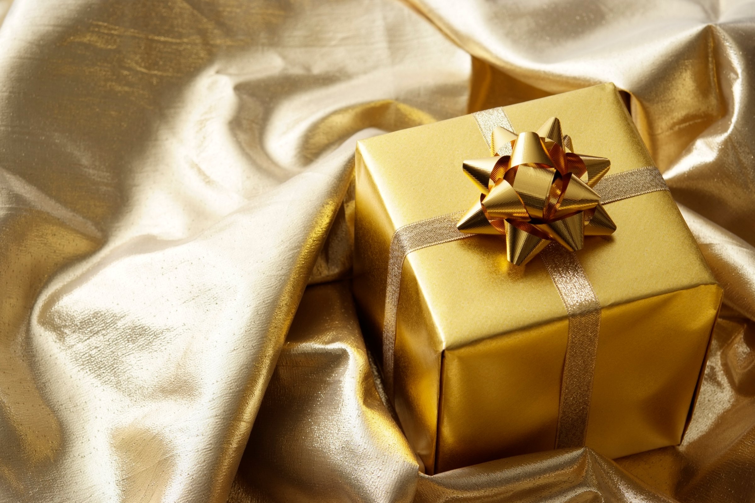 Gold gift box on gold cloth background