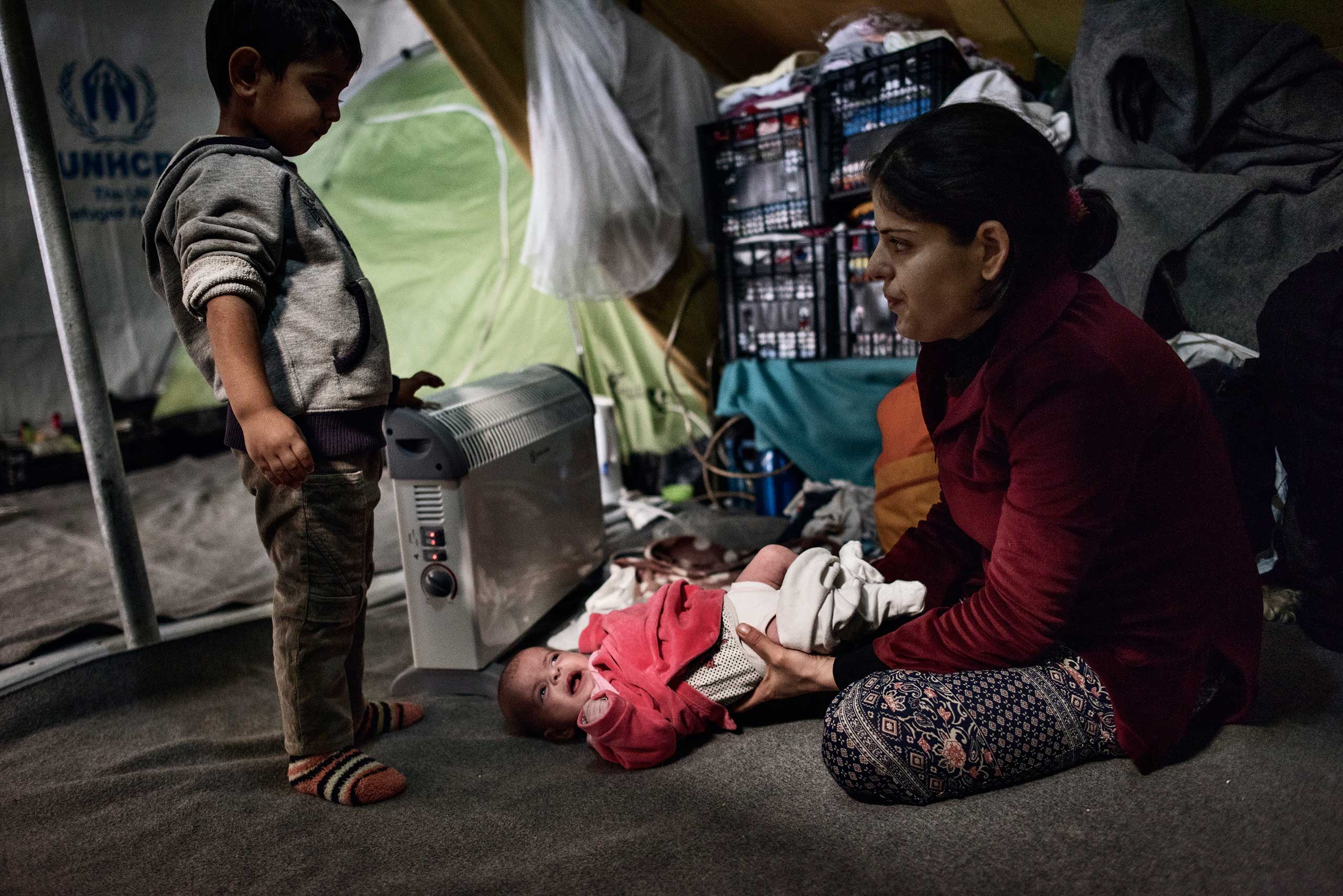 Dejla Alloush, 25, with her son and infant born on Oct. 6, 2016 at a camp in  Thessaloniki, Greece. She and her husband Mohammad, 40, are from Aleppo. Dejla is Mohammad's second wife. He married her because his first wife, Khelat, couldn't have children. Now Dejla worries she will be separated from her four children because Europeans do not accept polygamous marriages, Nov. 11, 2016.