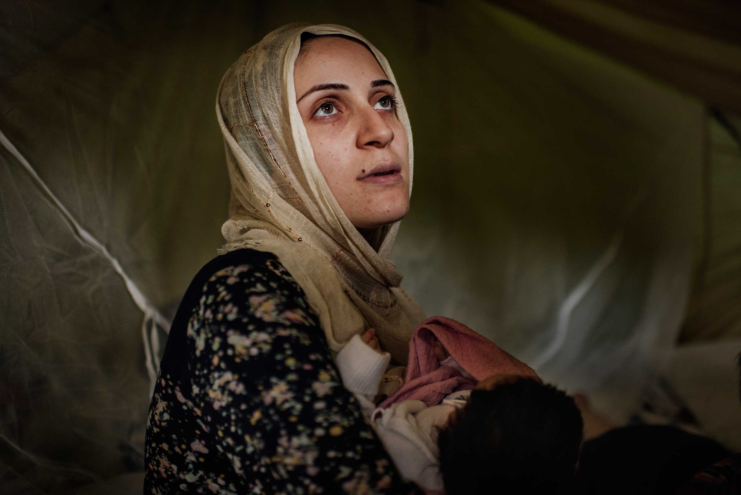 Taimaa Abazli, 24, holds her new baby Heln in their tent at the Karamalis camp in Thessaloniki, Greece, September 2016.