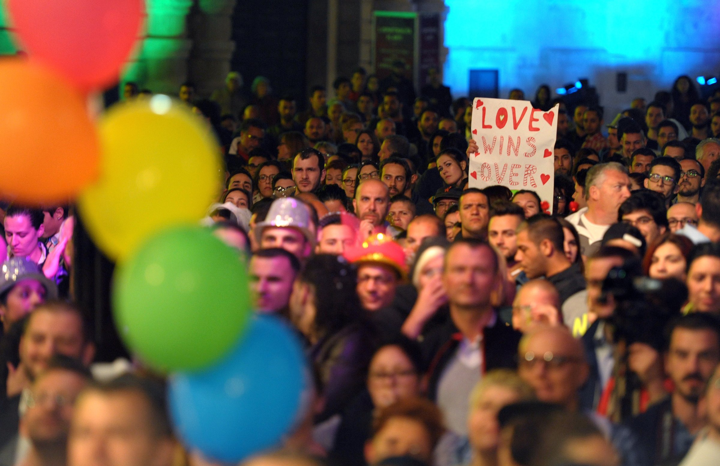 People gather to celebrate in Saint George's Square after the Maltese parliament approved a civil unions bill in Valletta on April 14, 2014. Malta's parliament approved the bill that grants marriage rights to homosexual couples, including the possibility to adopt children.