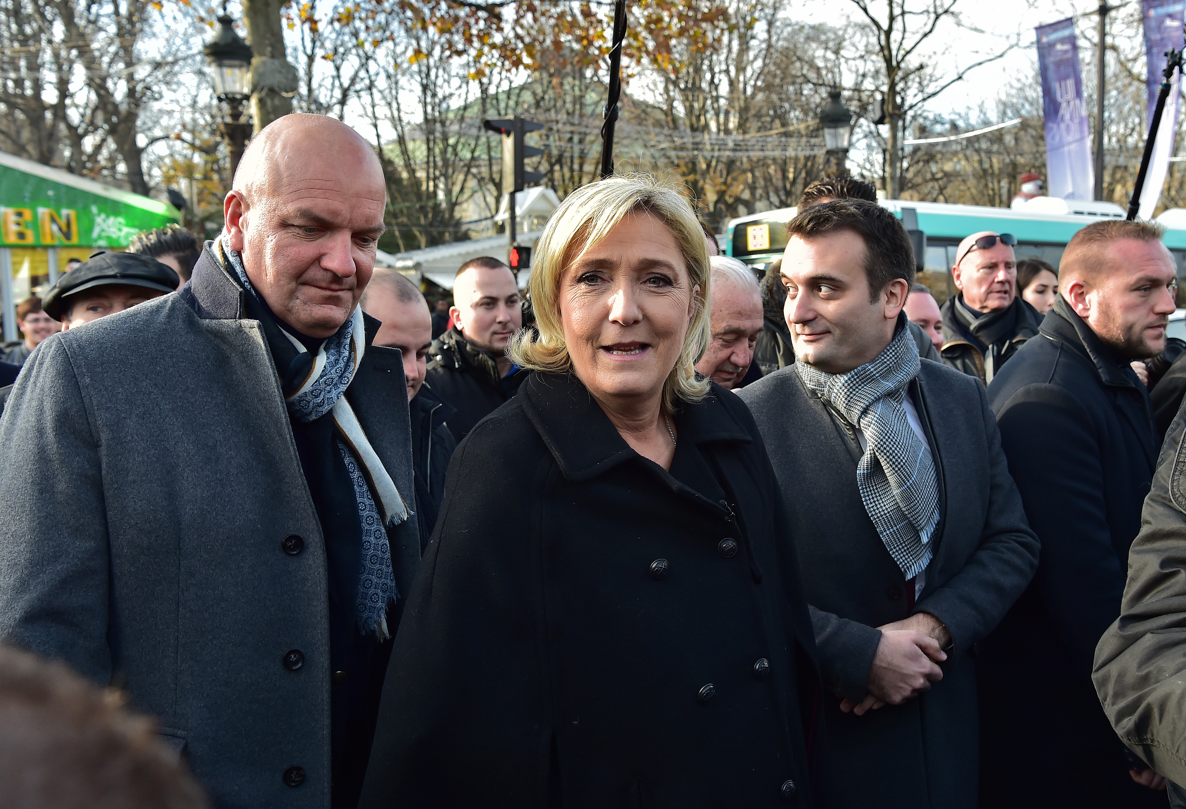 French far-right Front National (FN) party president, member of European Parliament and candidate for France's 2017 presidential election, Marine Le Pen (C) walks along with FN vice-president Florian Philippot (R) during a visit of a Christmas market in Paris on December 8, 2016. (Christophe Archambault—AFP/Getty Images)