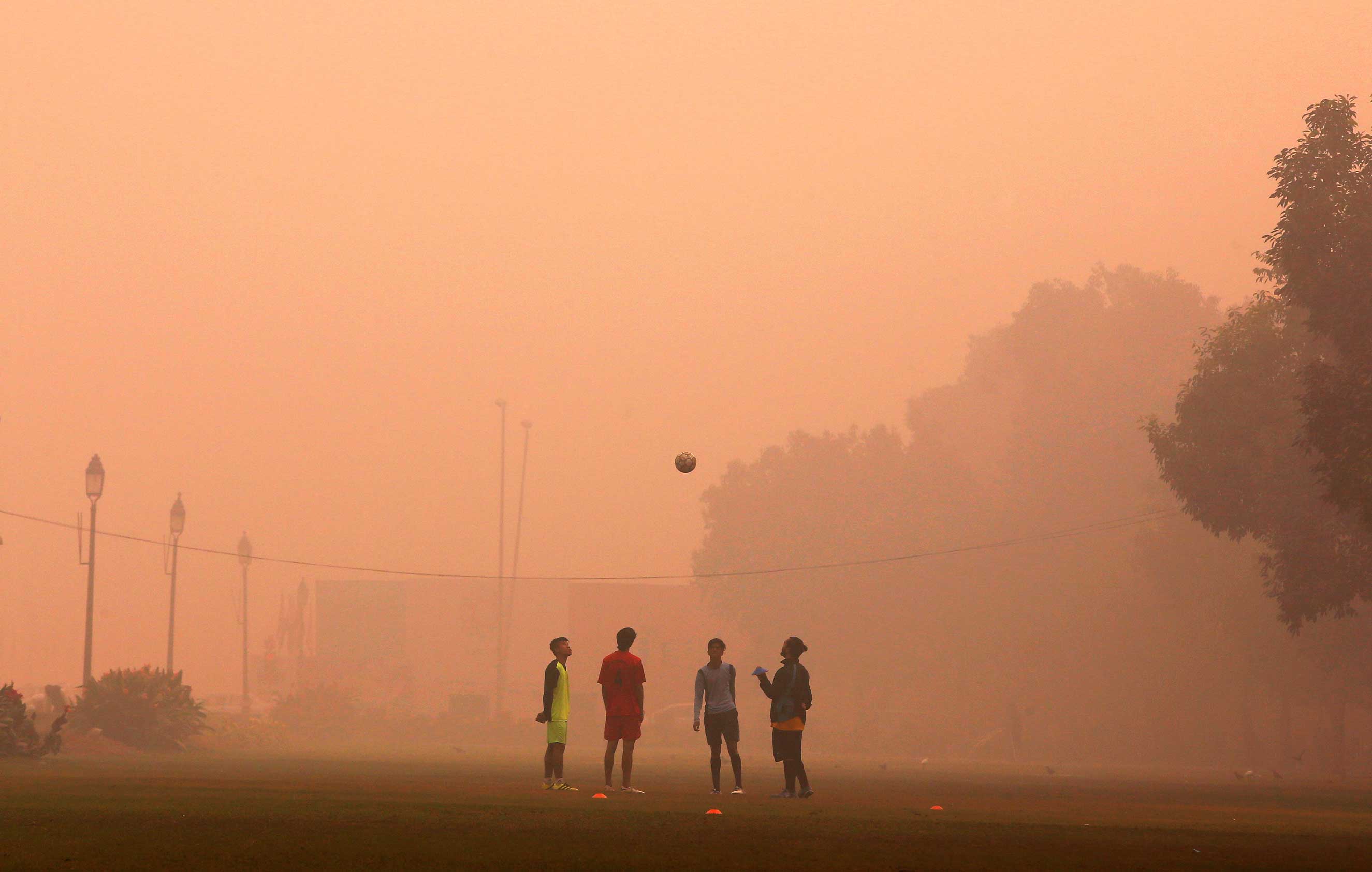 Children play on a smoggy day in New Delhi, where thousands die early from air pollution yearly (Adnan Abidi—Reuters)