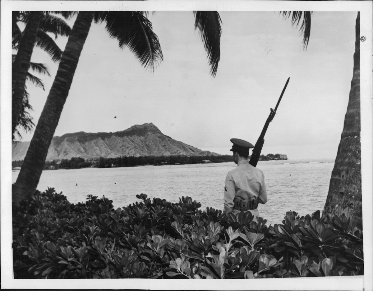 A sentry walks his post with a view of Diamond Head, marking Pearl Harbor U.S. Naval Base, in 1941. (Iconic Archive / Getty Images)