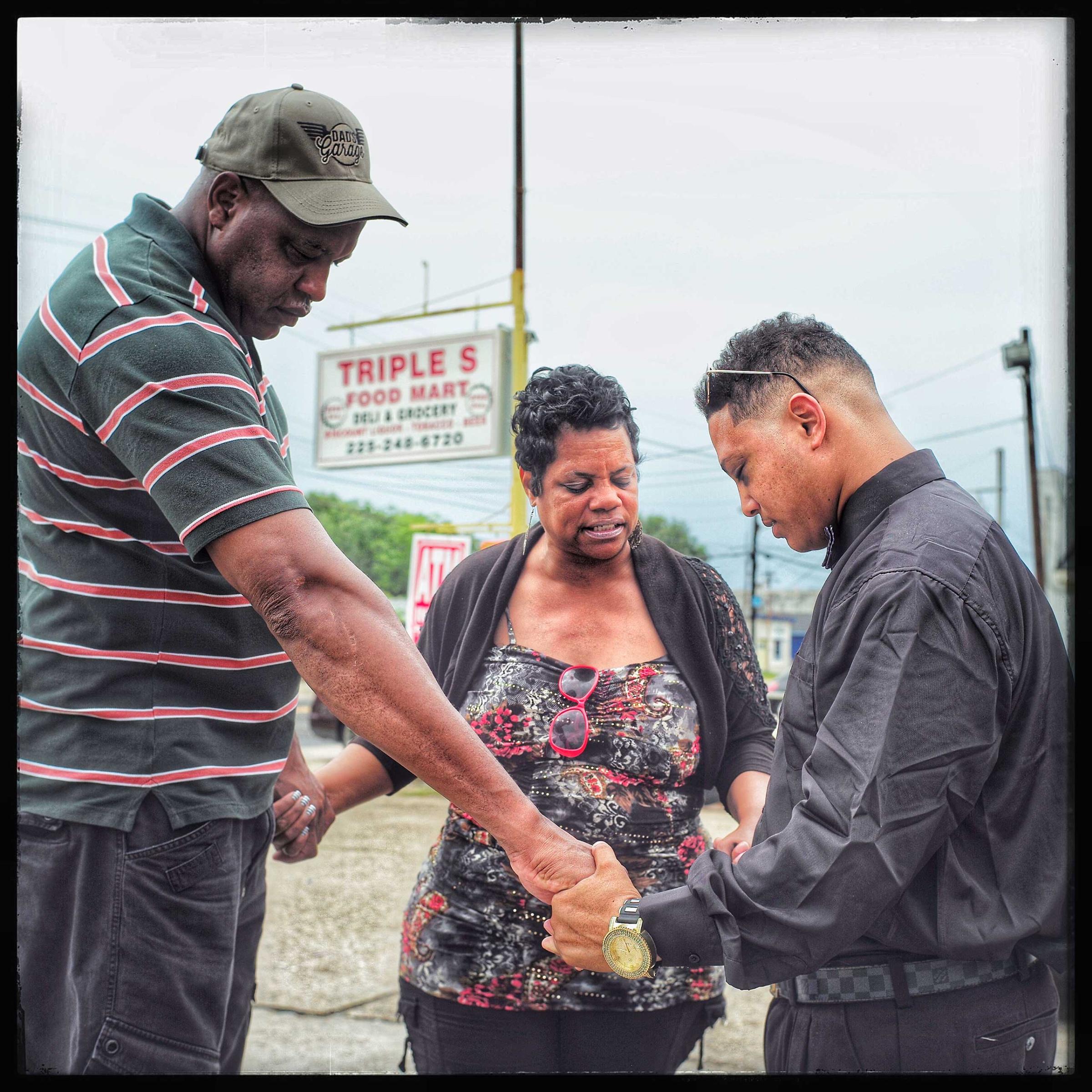 Praying for a successful meeting with 24 year old javier Dunn (far left). Dunn, who was arrested for protesting the Alton Sterling shooting by the Baton Rouge Police Department, was told he had to go see his parol officer as a condition of his release. Here, two community pastors pray with him before his meeting.