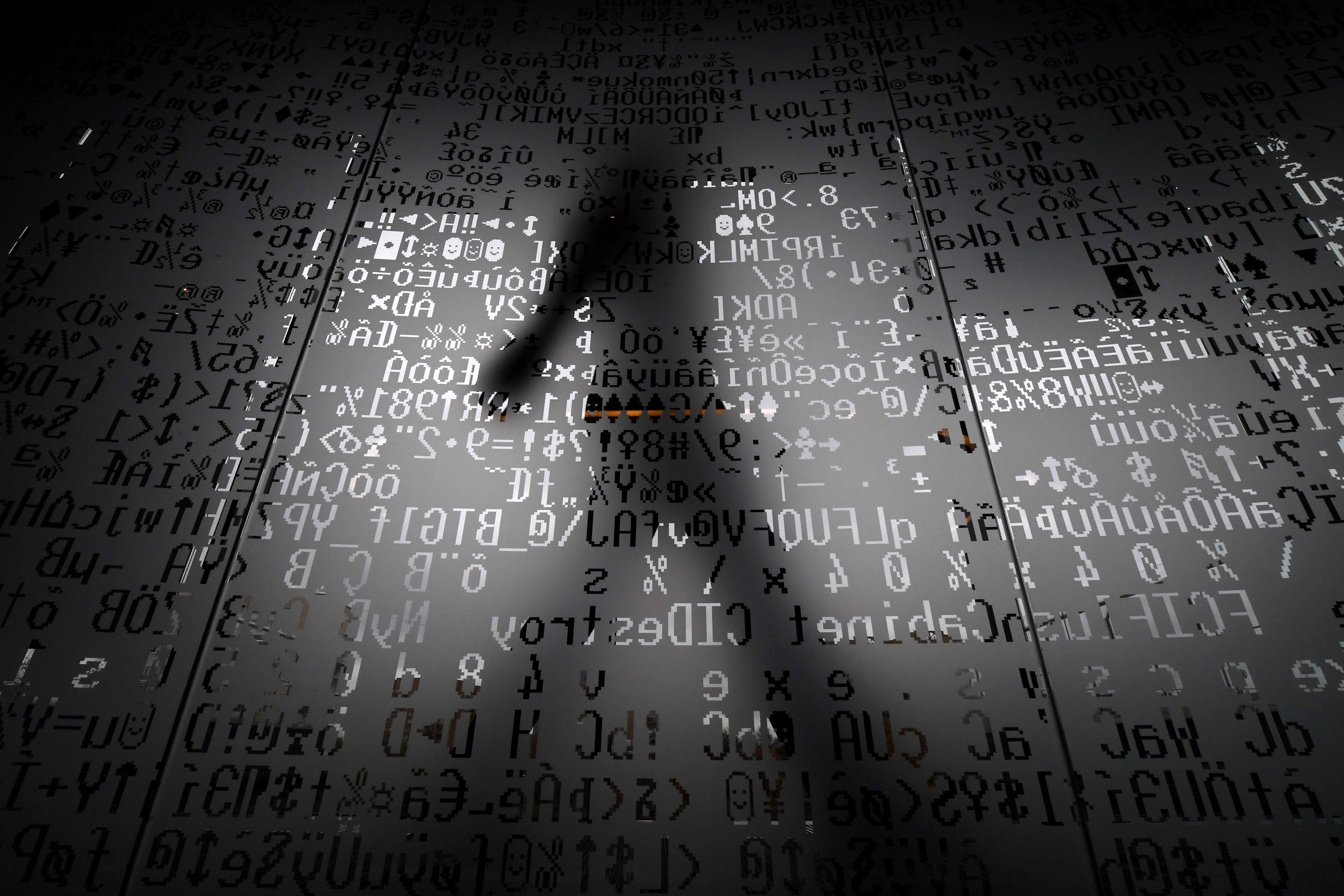 An employee walks behind a glass wall with machine coding symbols at the headquarters of Internet security giant Kaspersky in Moscow on Oct 17, 2016. (Kirill Kudryavtsev—AFP/Getty Images)