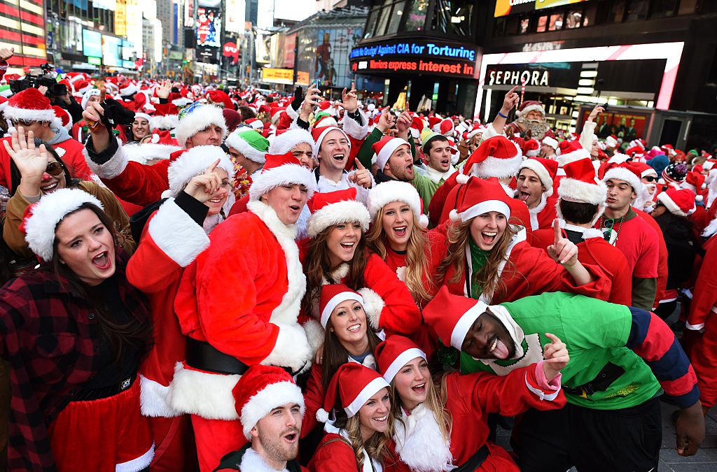 People dressed as Santa Claus and Mrs. Claus pose in Times Square as they gather for the annual Santacon festivities on Dec. 13, 2014 in New York City.