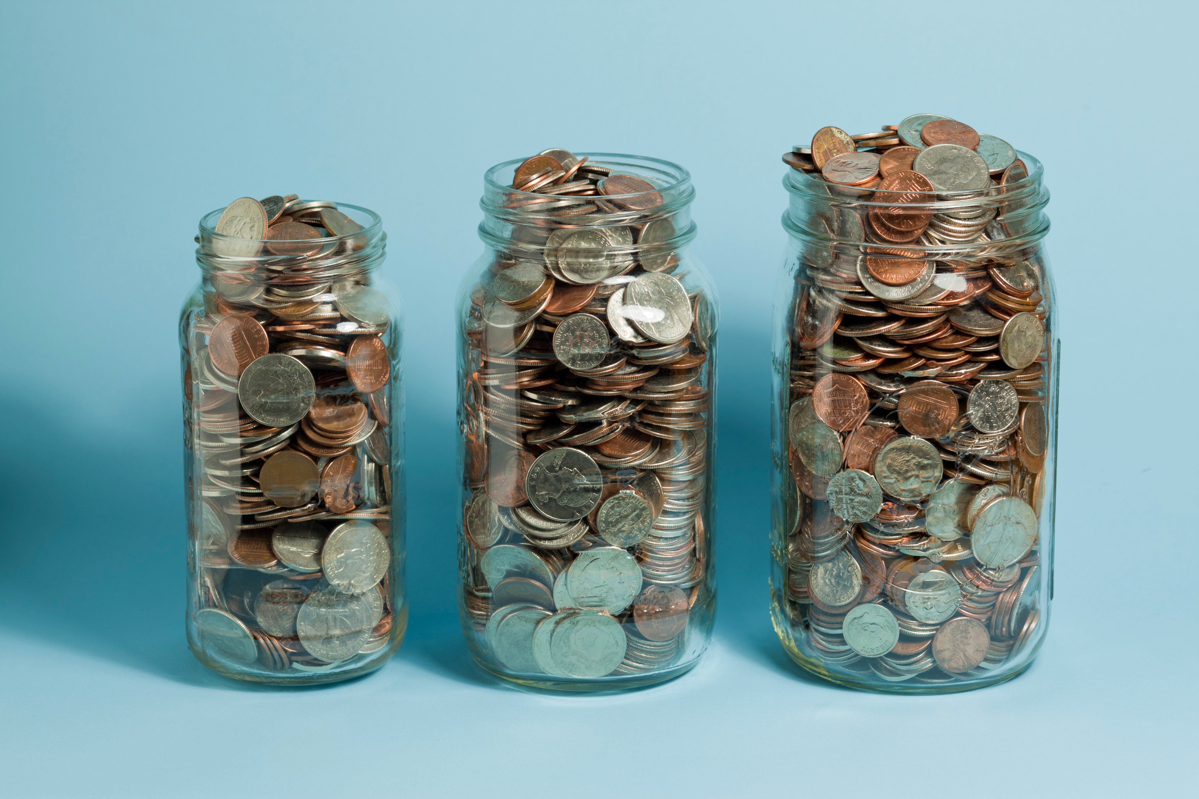 Three Mason jars filled with American coins. The jars get bigger left to right. (Steve Lewis Stock—;Getty Images)