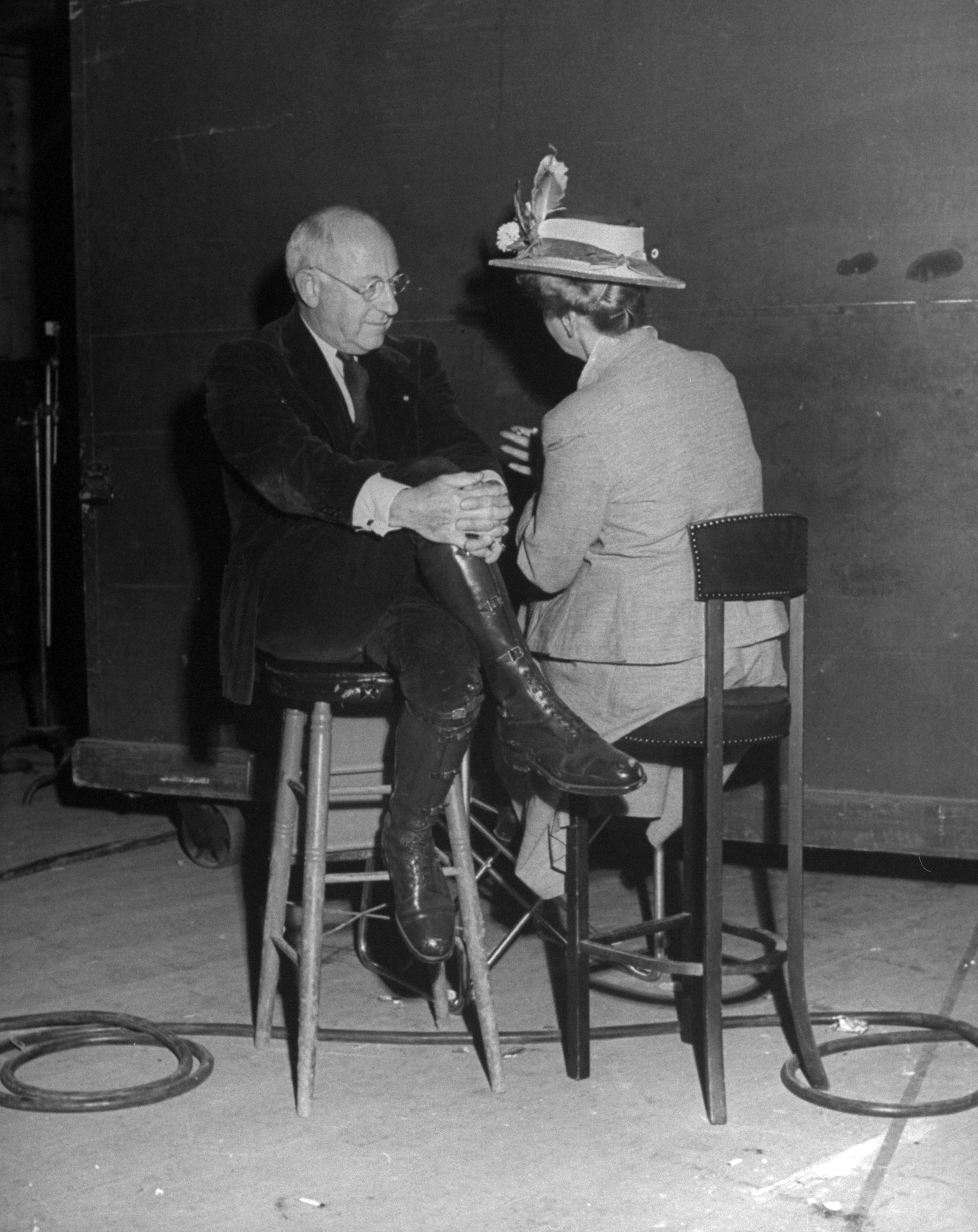 Cecil B. DeMille and Hedda Hopper, sitting down and chatting during the filming of 'Sunset Blvd,' 1949.