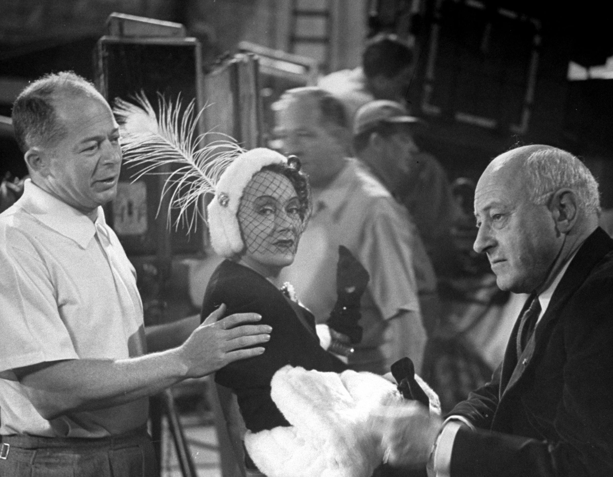 Billy Wilder talking with actress Gloria Swanson and Cecil B. DeMille during the shooting of the movie 'Sunset Blvd,' 1949.