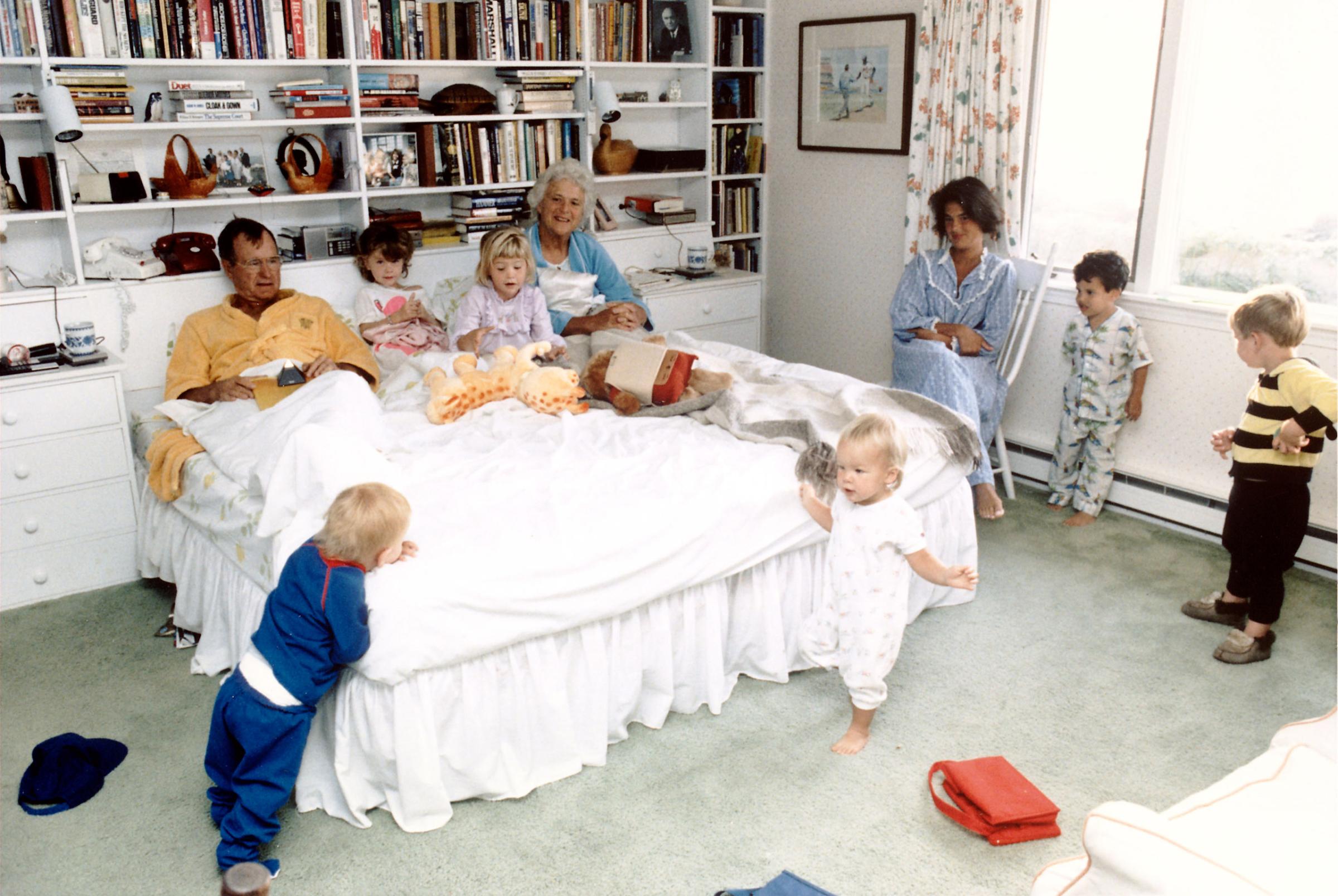 President George H.W. and Barbara Bush in bedroom get-together with their grandchildren (L-R) Pierce, twins Barbara and Jenna (in bed), Marshall, Jeb. Jr. and Sam LeBlond. 1987.