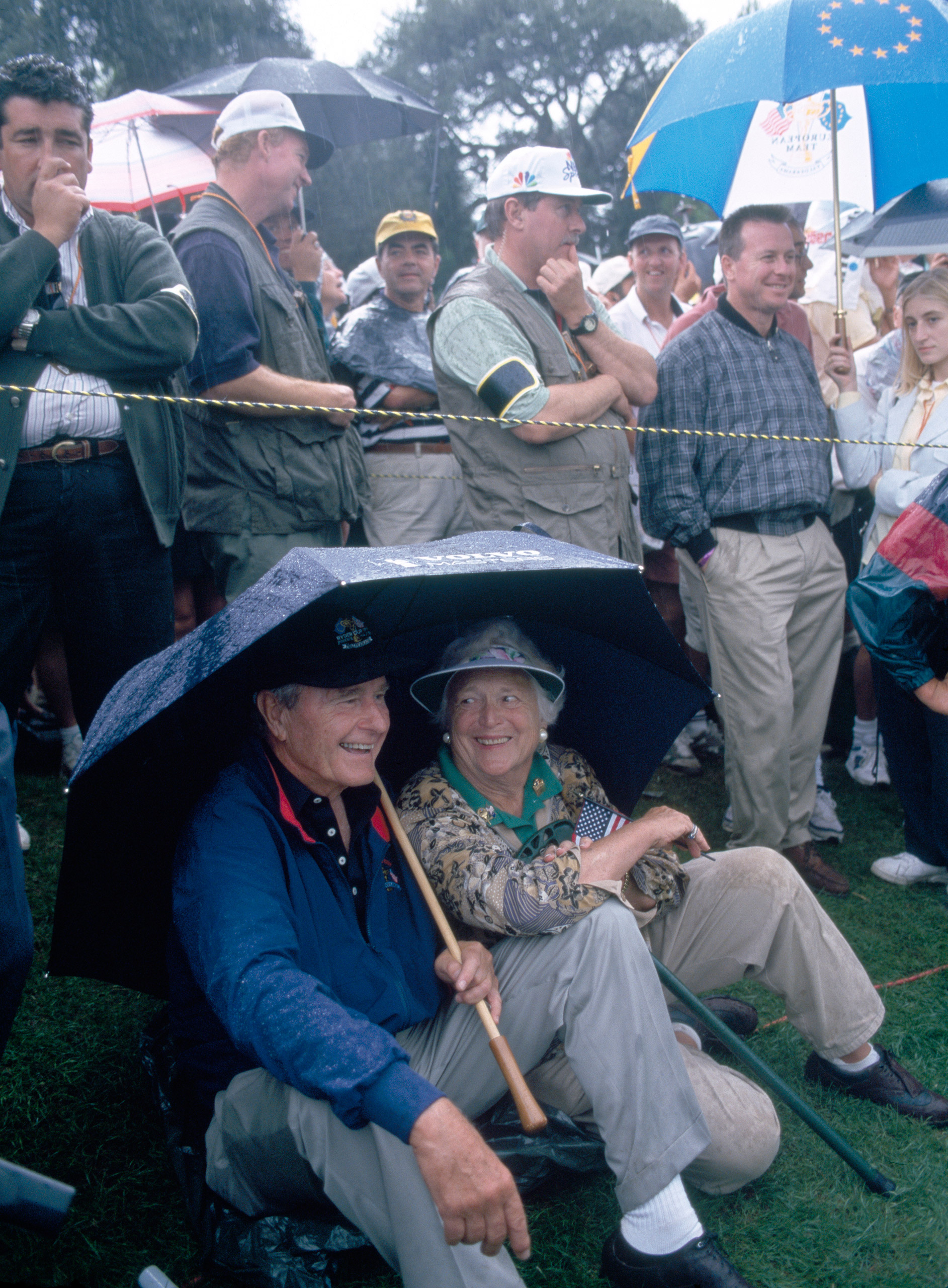 Former United States President George H.W. Bush and his wife Barbara shelter from the rain during the Ryder Cup golf competition held at the Valderrama Golf Club, Spain, Sept. 26, 1997.