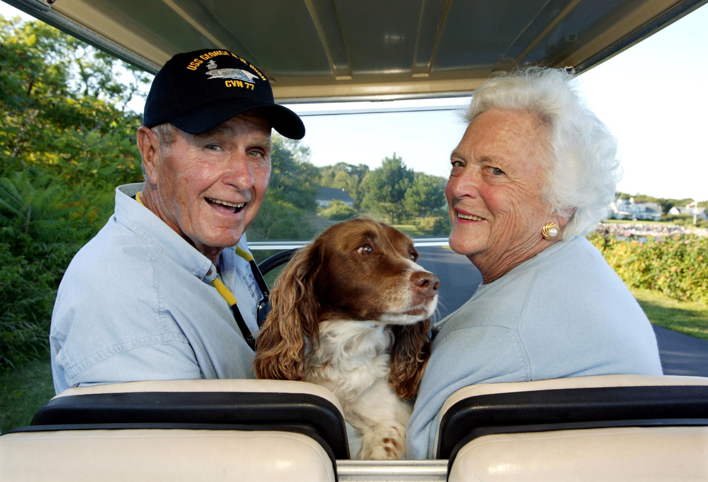 Former U.S. president George H. W. Bush and wife, Barbara Bush, cruise in the back of a golf cart with their dog Millie at their home at Walker's Point on Aug. 25, 2004 in Kennebunkport, ME.