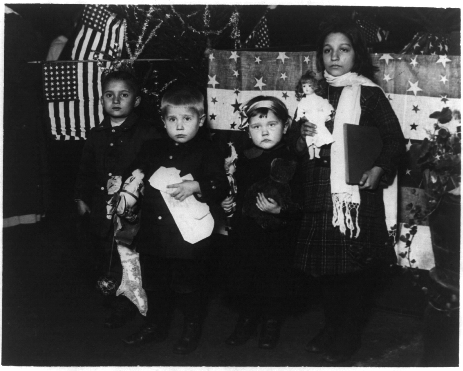 Four immigrant children posed for their first Christmas in America at Ellis Island, circa 1918.
