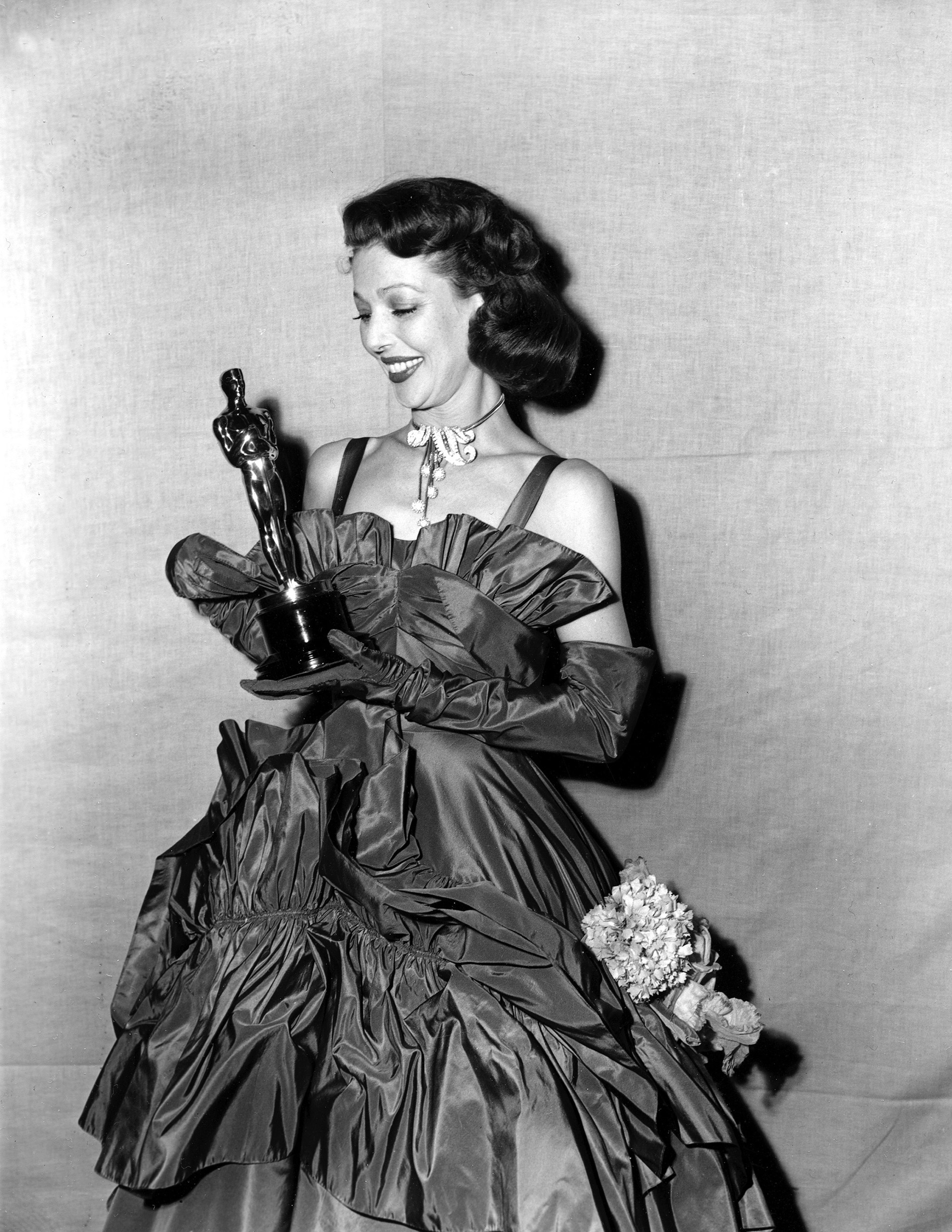 Loretta Young looks at her Oscar at the Academy Awards, 1948.