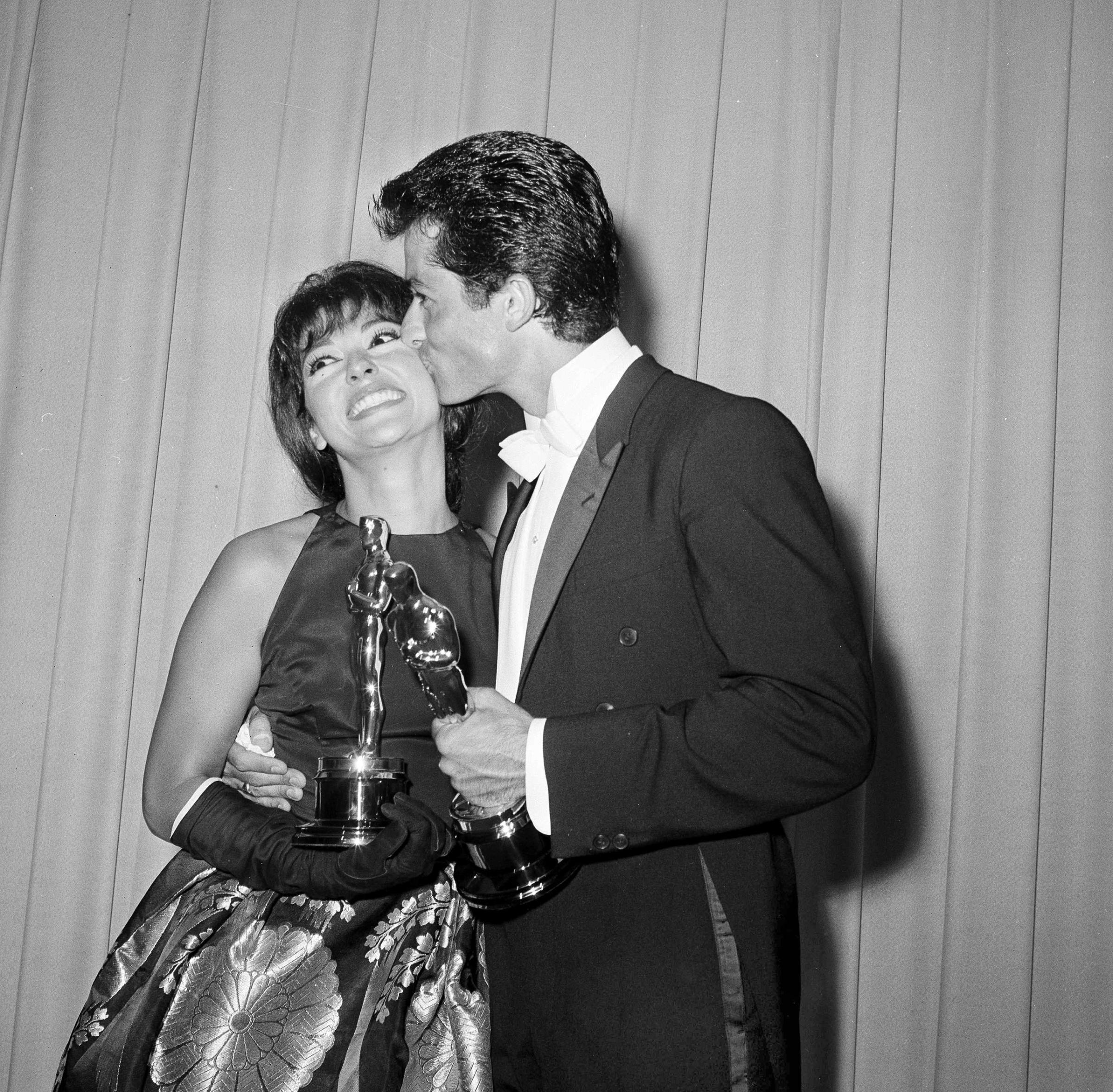Rita Moreno gets a kiss from dancer and actor George Chakiris after they each won Academy Awards, 1962.