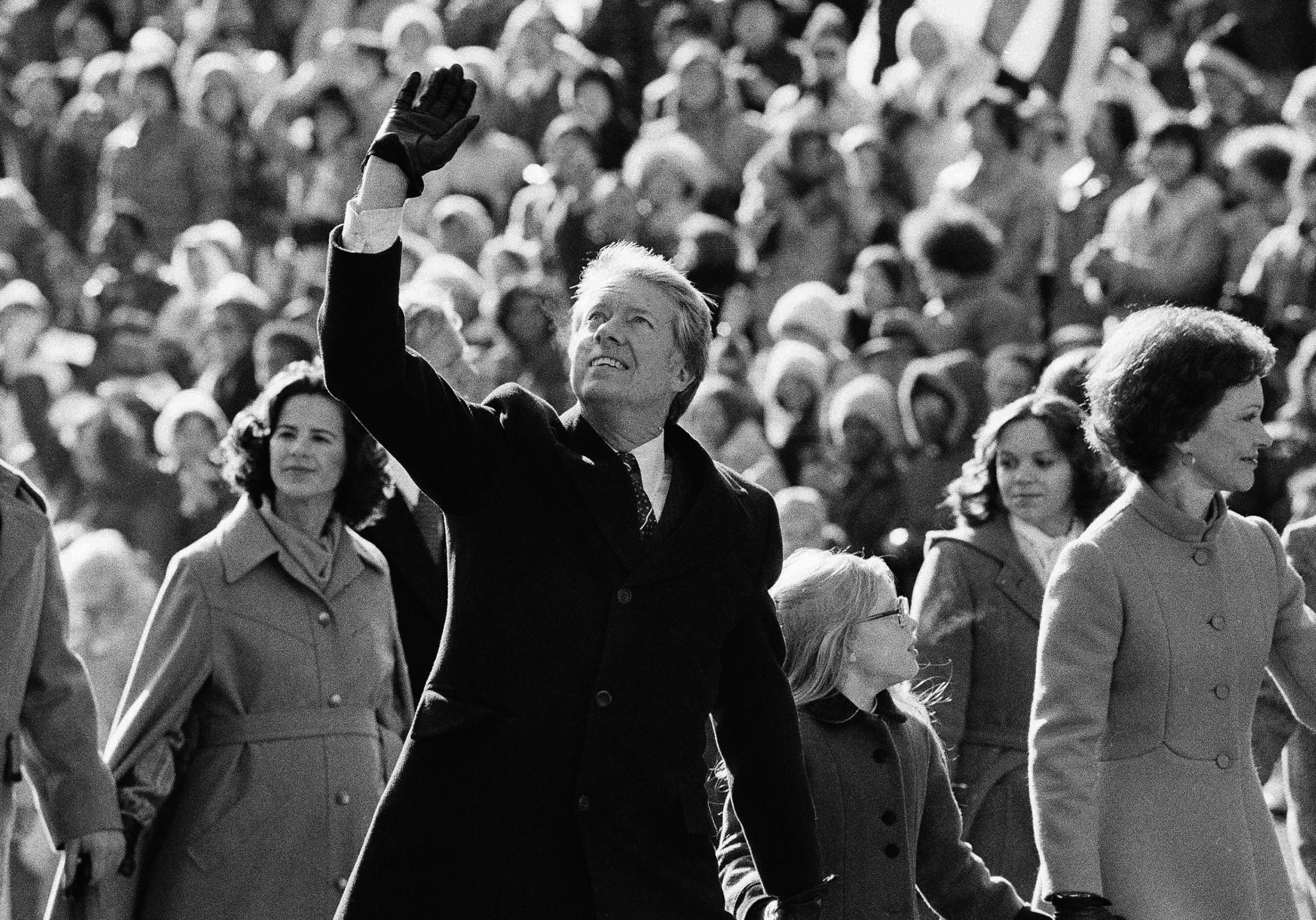 President Jimmy Carter waves to the crowd while walking with his wife Rosalynn along Pennsylvania Avenue and their daughter Amy. The Carters elected to walk the parade route from the Capitol to the White House following his inauguration in Washington, on Thursday, Jan. 20, 1977.