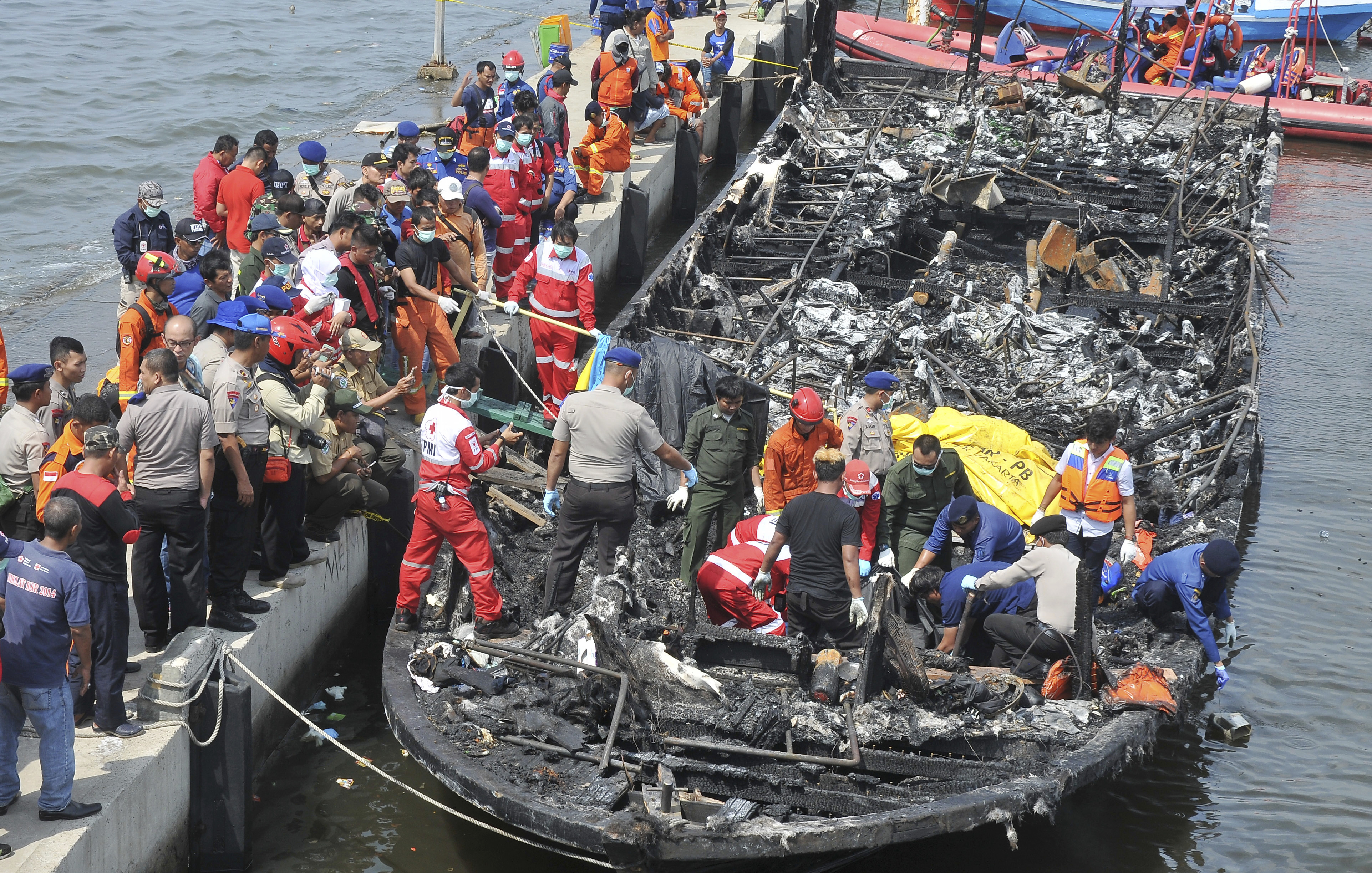 Rescuers search for victims from the wreckage of a ferry that caught fire off the coast of Jakarta on Jan. 1, 2017. (Rhana Ananda—AP)