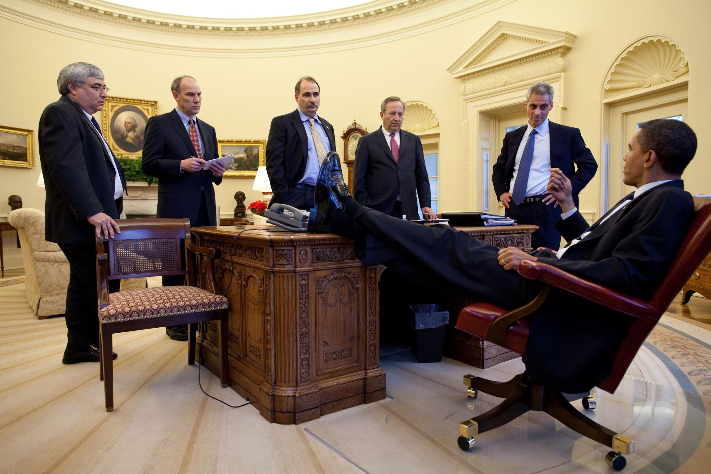 “The President talks with aides during an impromptu meeting around the Resolute desk.” Feb. 4, 2009