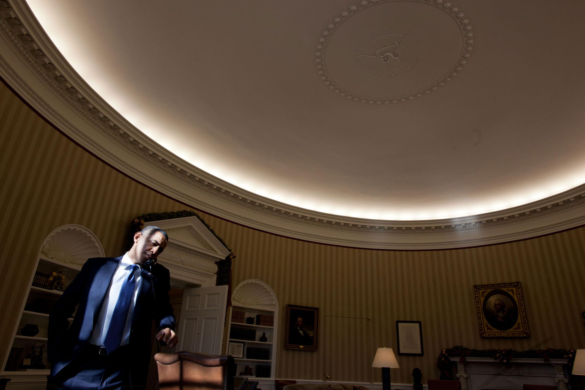 President Barack Obama talks on the phone in the Oval Office, Dec. 19, 2011.