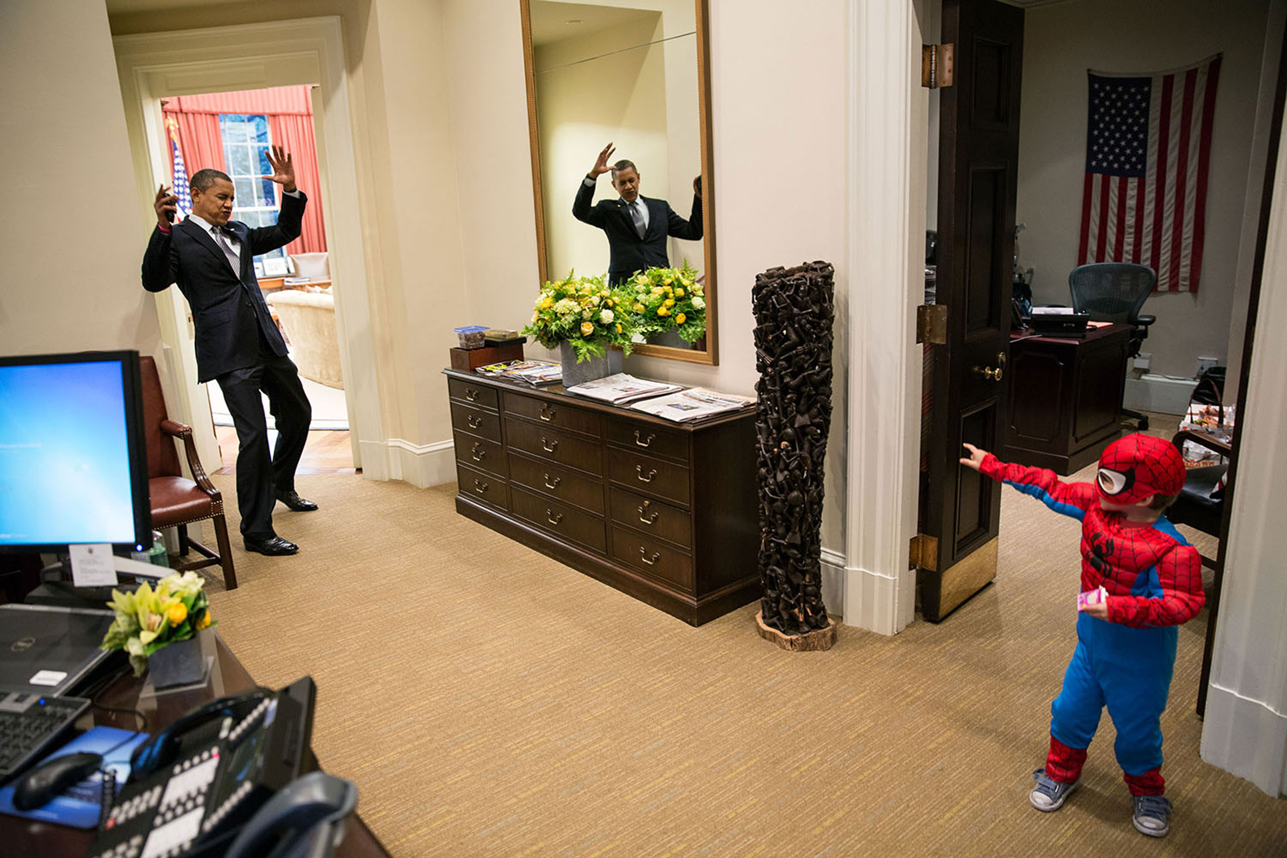 President Barack Obama pretends to be caught in Spider-Man's web as he greets the son of a White House staffer in the Outer Oval Office, Oct. 26, 2012.