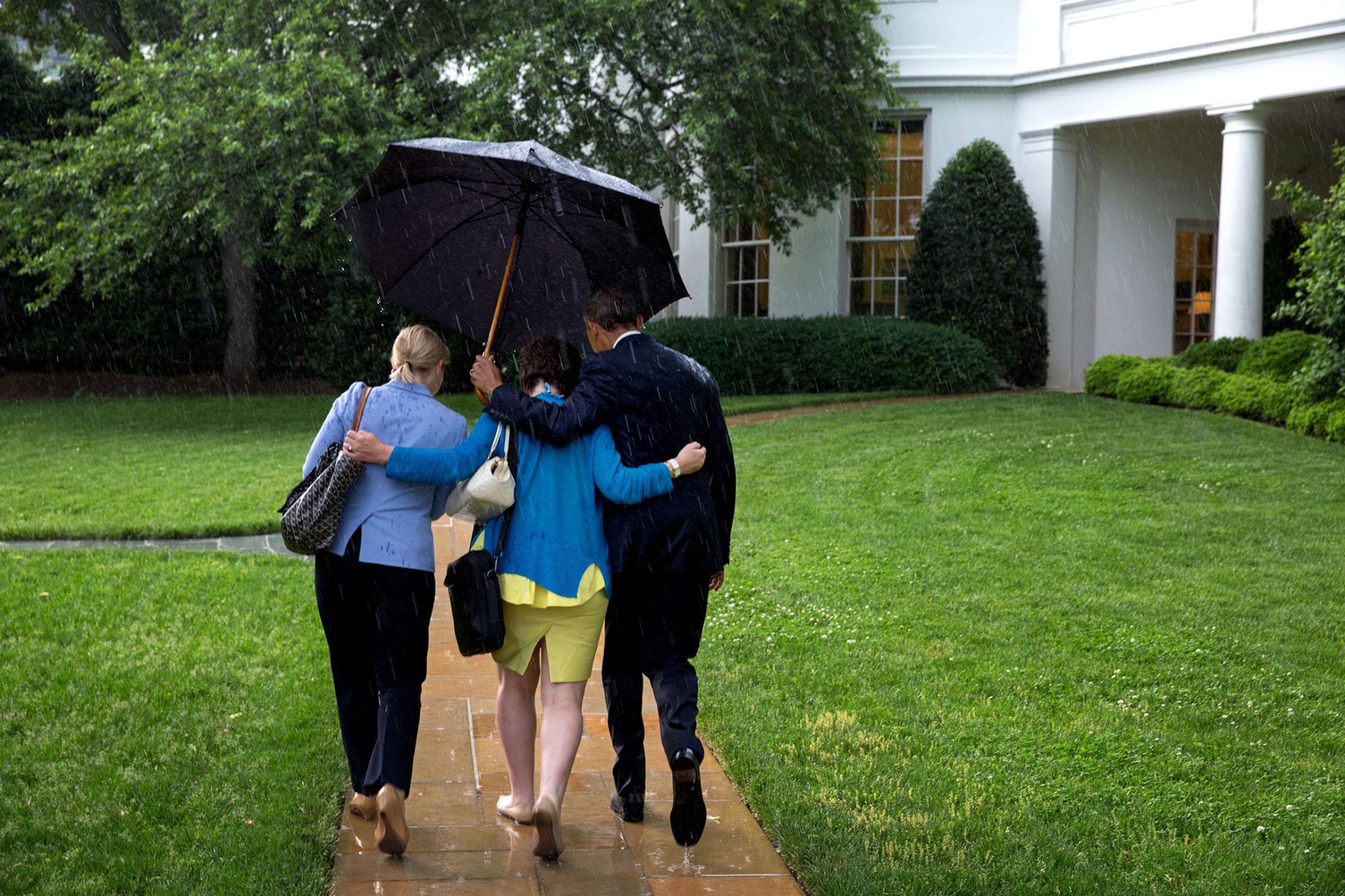 After returning on Marine One, the President walks from the helicopter to the Oval Office holding an umbrella for aides Valerie Jarrett and Anita Decker Breckenridge," May 18, 2015.