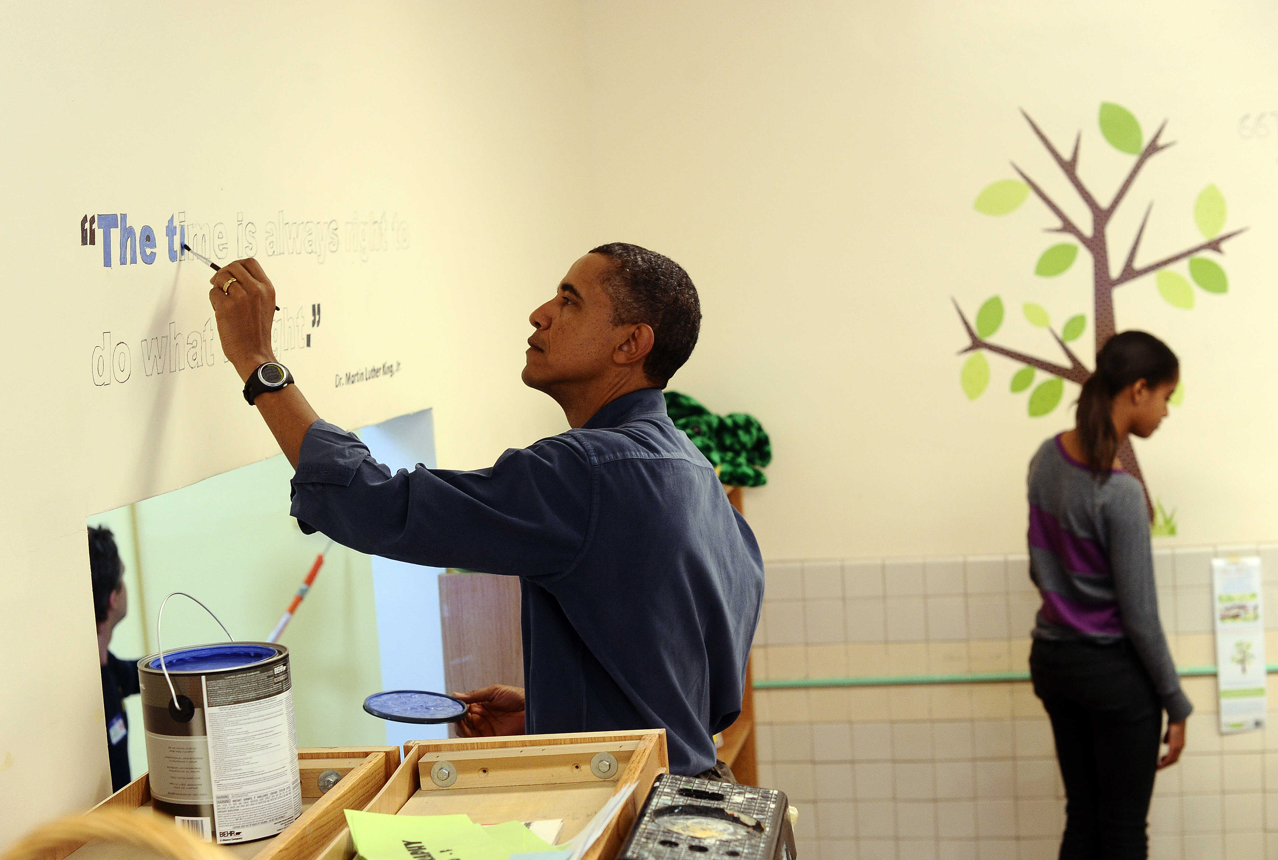 US President Barack Obama (L) paints a quote of Martin Luther King Jr. on the wall of a library at the Browne Education Center in Washington, D.C., on January 16, 2012, as taking part in a community service project. (Jewel Samad&mdash;AFP/Getty Images)