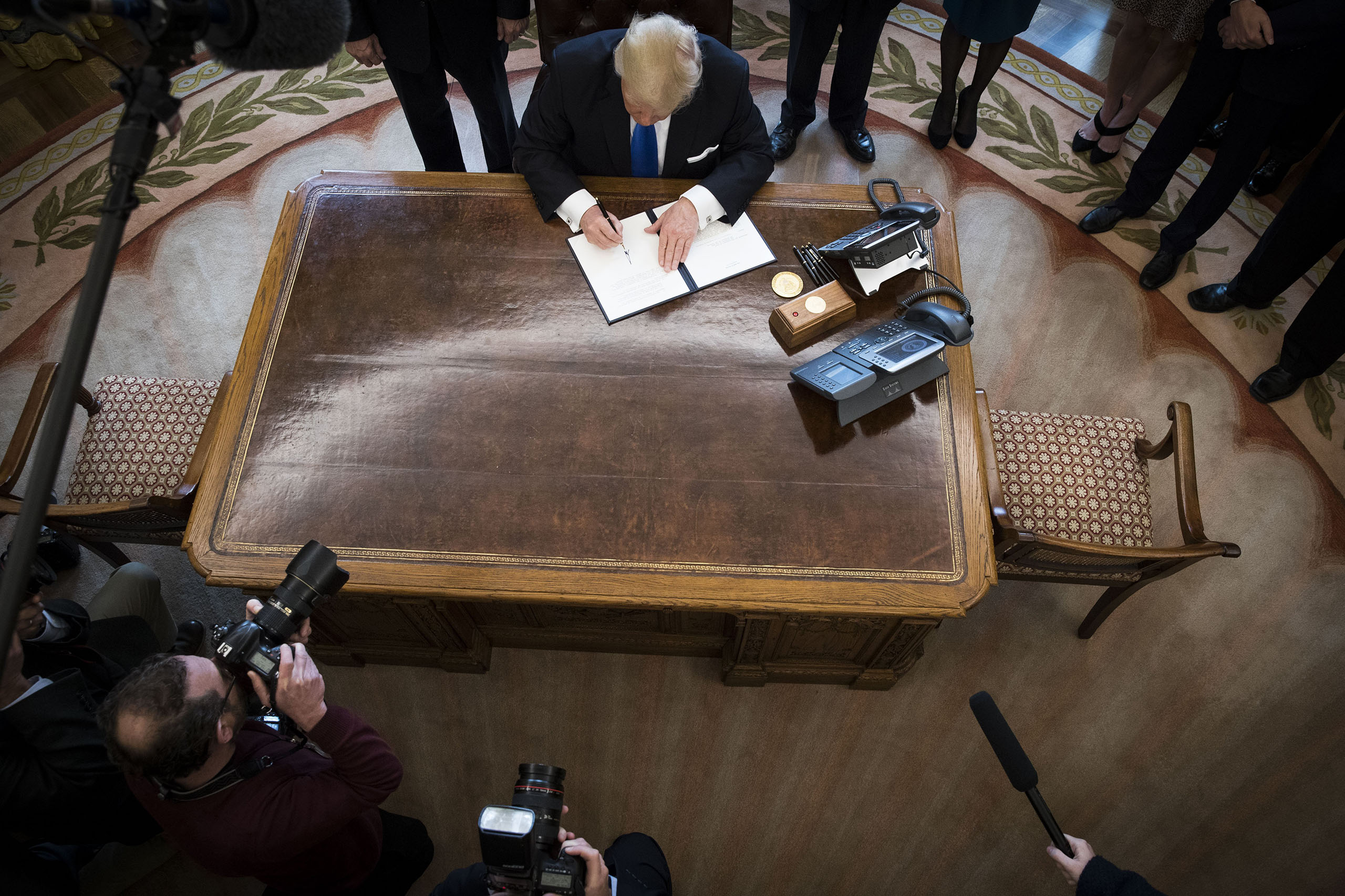 President Donald Trump signs an executive order in the Oval Office of the White House, on Jan. 24, 2017.