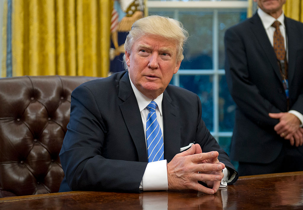 U.S. President Donald Trump prepares to sign three Executive Orders in the Oval Office of the White House in Washington, DC on Monday, January 23, 2017. (Pool—Independent Still Pool photo ©2017 Consolidated News Photos All Rights Reserved)