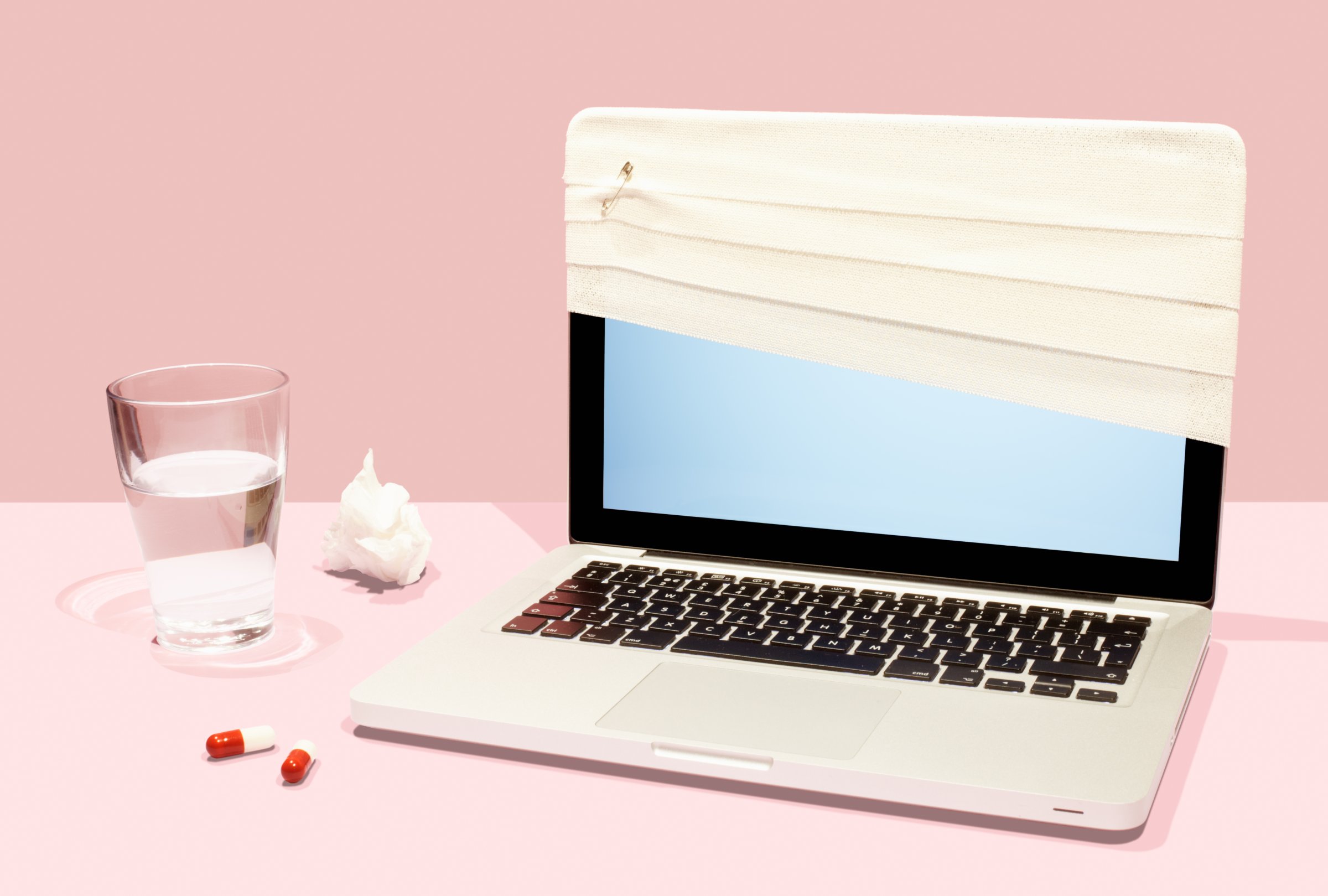 Sick laptop with bandage and pills.