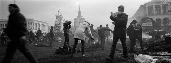 UKRAINE. Kiev. February 2014. Protesters clean away debris and re-build barricades in Independence (Maidan) Square after a long night of clashes with riot police.