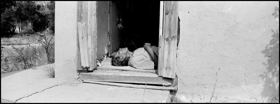 USA. Pine Ridge, South Dakota. 2015. Man passed out in doorway of abandoned home used for parties and drinking binges.