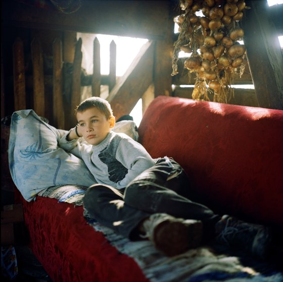 Andrei Rus, 12, relaxes in his father’s palinca still in Strâmtura. Palinca—the name for all kinds of fruit brandy—can be as much as 58 proof here. The stills require copious amounts of cooling water and are nearly always on the banks of streams—as are fulling machines, which use water-driven hammers to thicken up the fibers of woolen cloth. Maramures, Romania. November, 2012