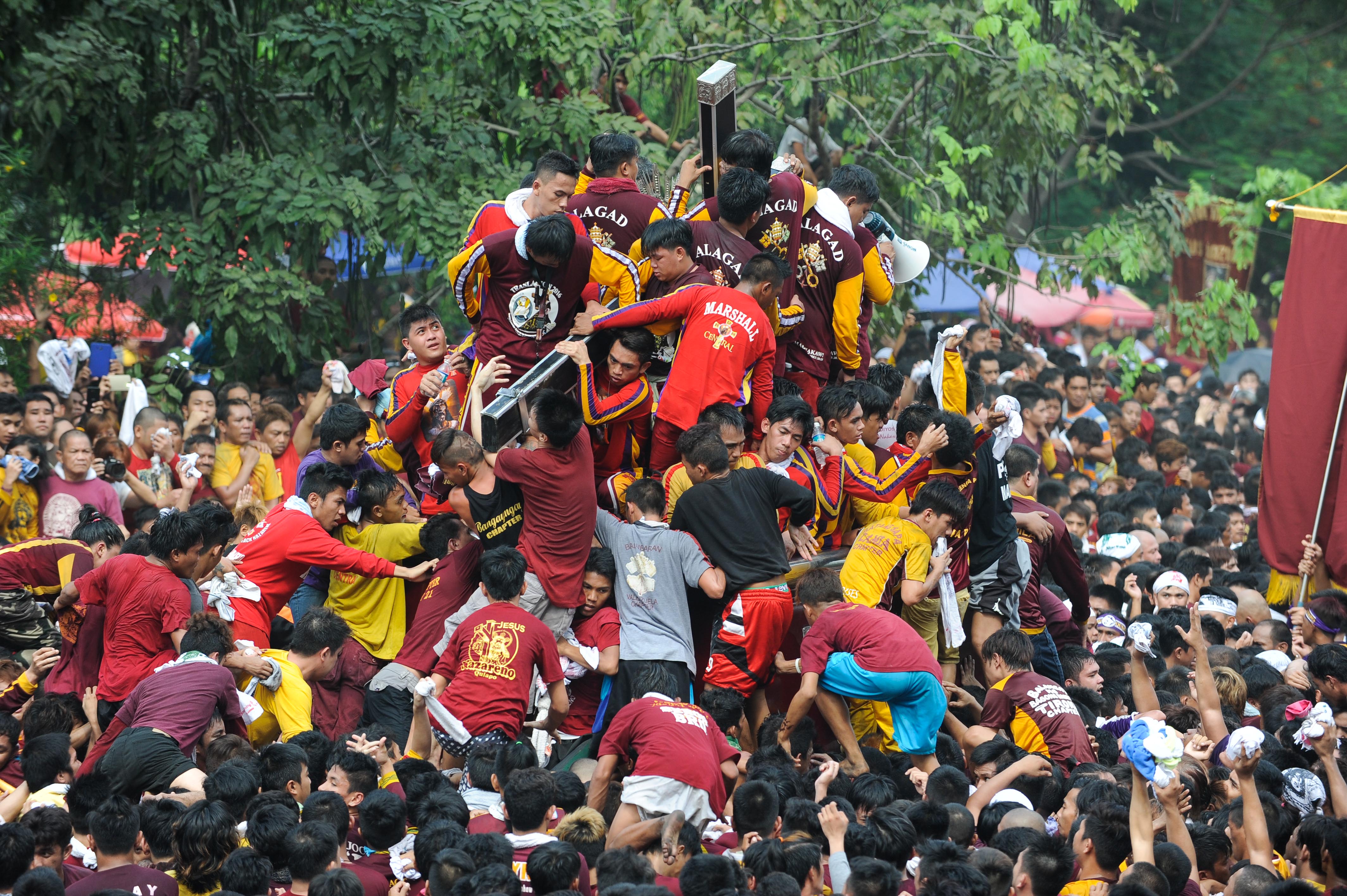 Devotees climb the carriage of the Black Nazarene during the Feast of the Black Nazarene on Jan. 9, 2016, in Manila (Dondi Tawatao—Getty Images)