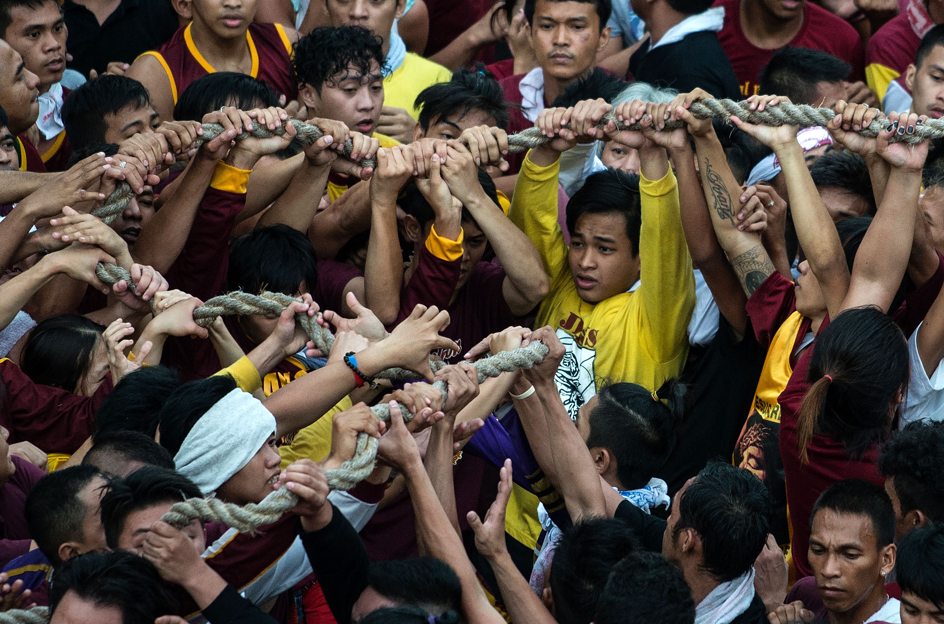 Devotees touch the rope used to pull the carriage carrying the life-size statue of the Black Nazarene on Jan. 9, 2017 (Noel Celis—AFP/Getty Images)