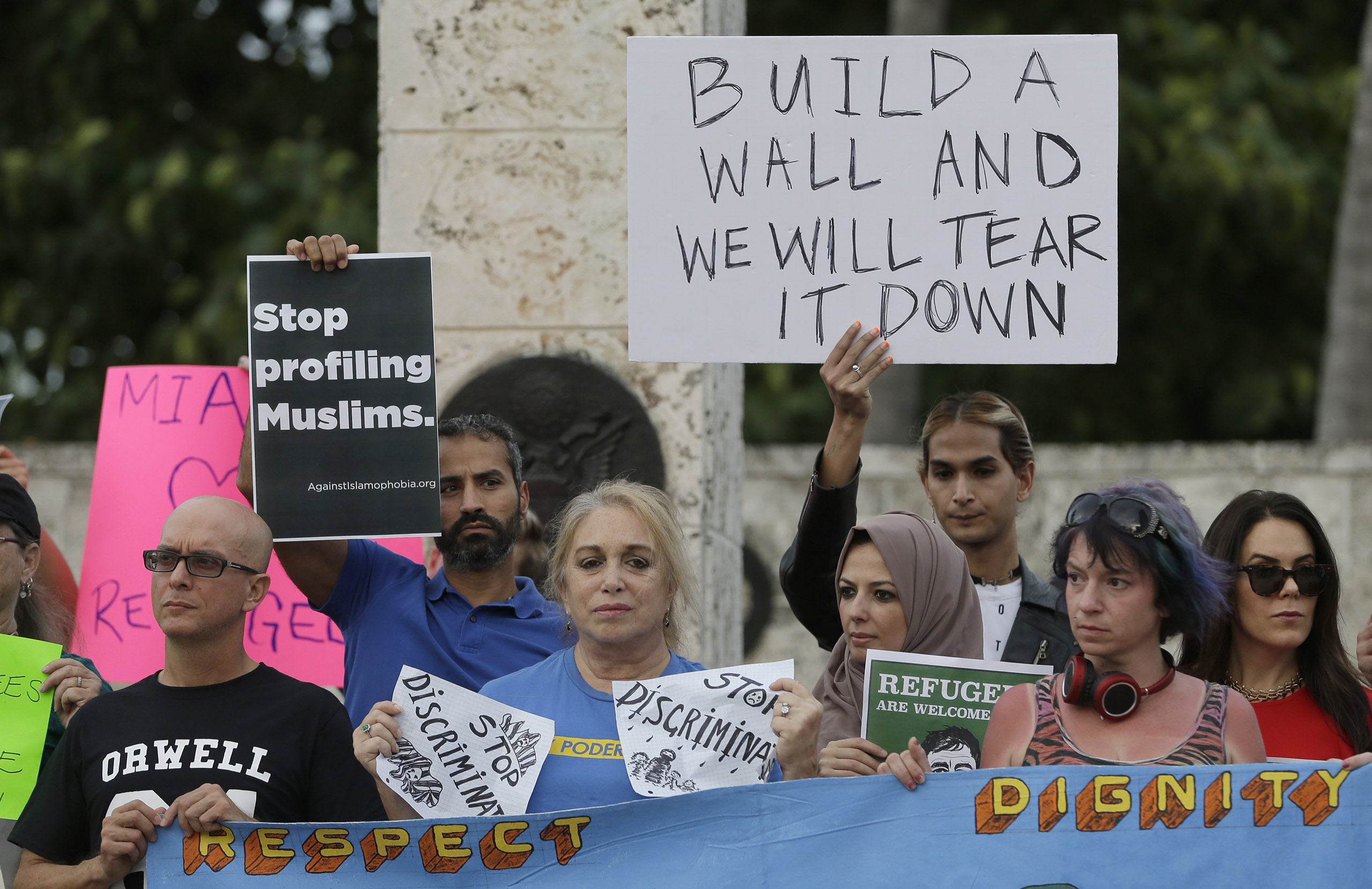Protesters hold signs during a rally against President Donald Trump's executive order on immigration in downtown Miami. on Jan. 26, 2017. (Alan Diaz—AP)