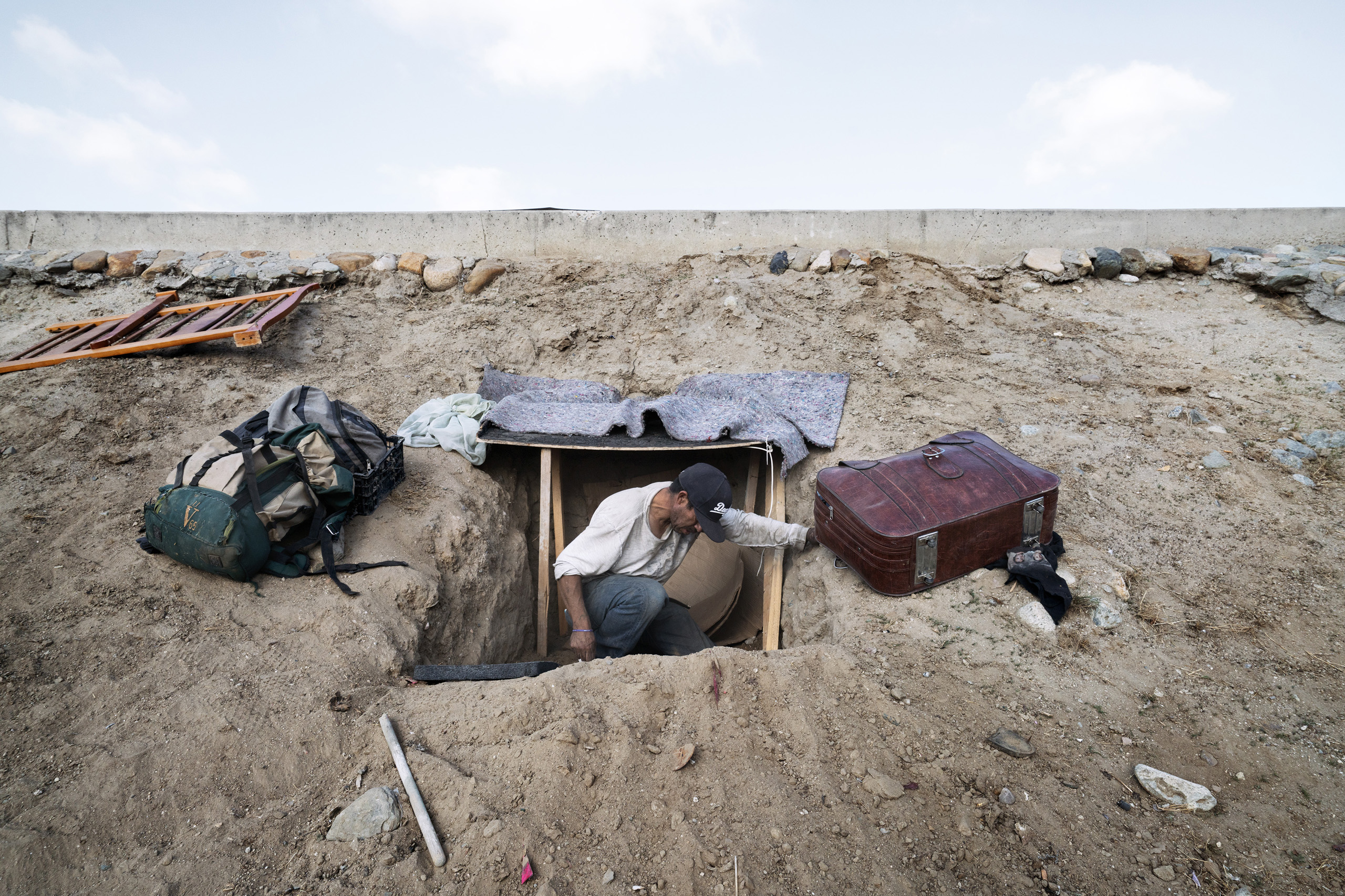 Along the border between Mexico and the U.S., José, a Mexican migrant from Guadalajara, is building a shelter just few paces from the border, waiting for the right time to cross. Tijuana, Baja California, Mexico. Oct. 13, 2016.