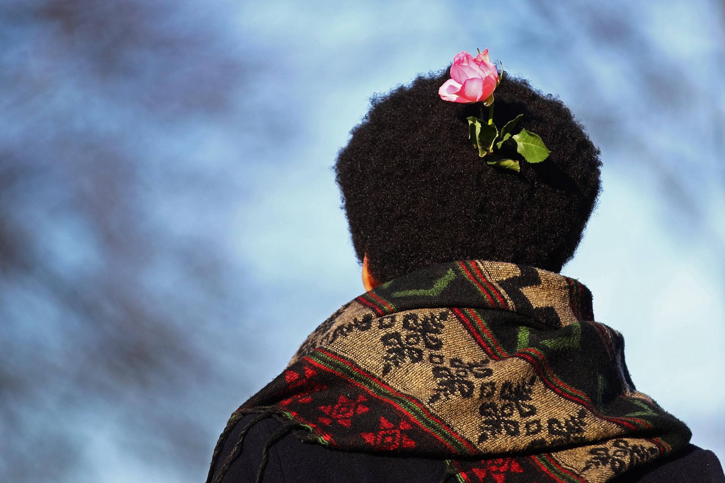A demonstrator with a pink flower in his hair joins the crowd as they make their way towards the US Consulate during the Women's March held at Museumplein on January 21, 2017 in Amsterdam, Netherlands.