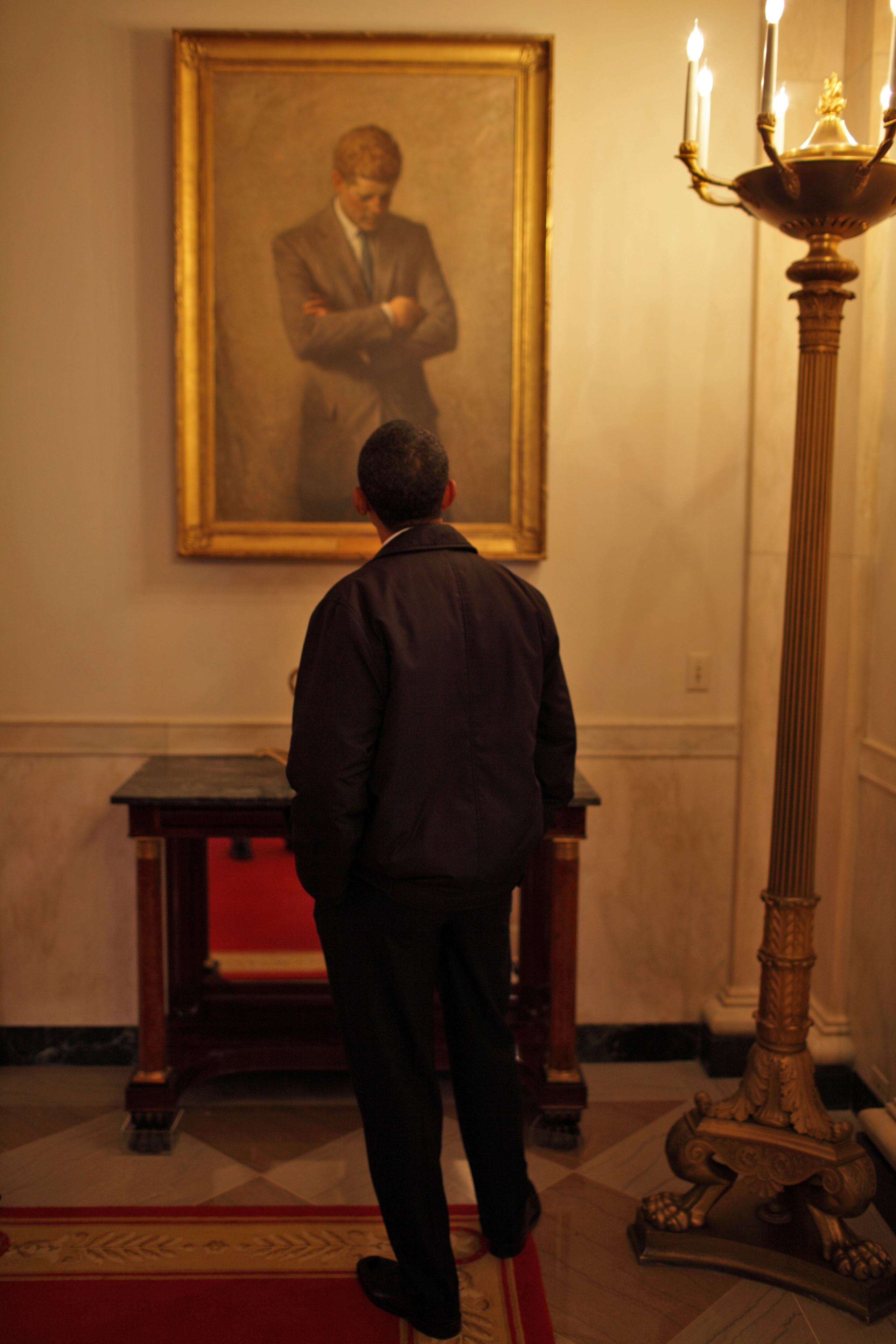 President Barack Obama checks out a portrait of President John Kennedy during an historical tour of the White House residence and grounds in Washington, DC., on Jan. 21, 2009.