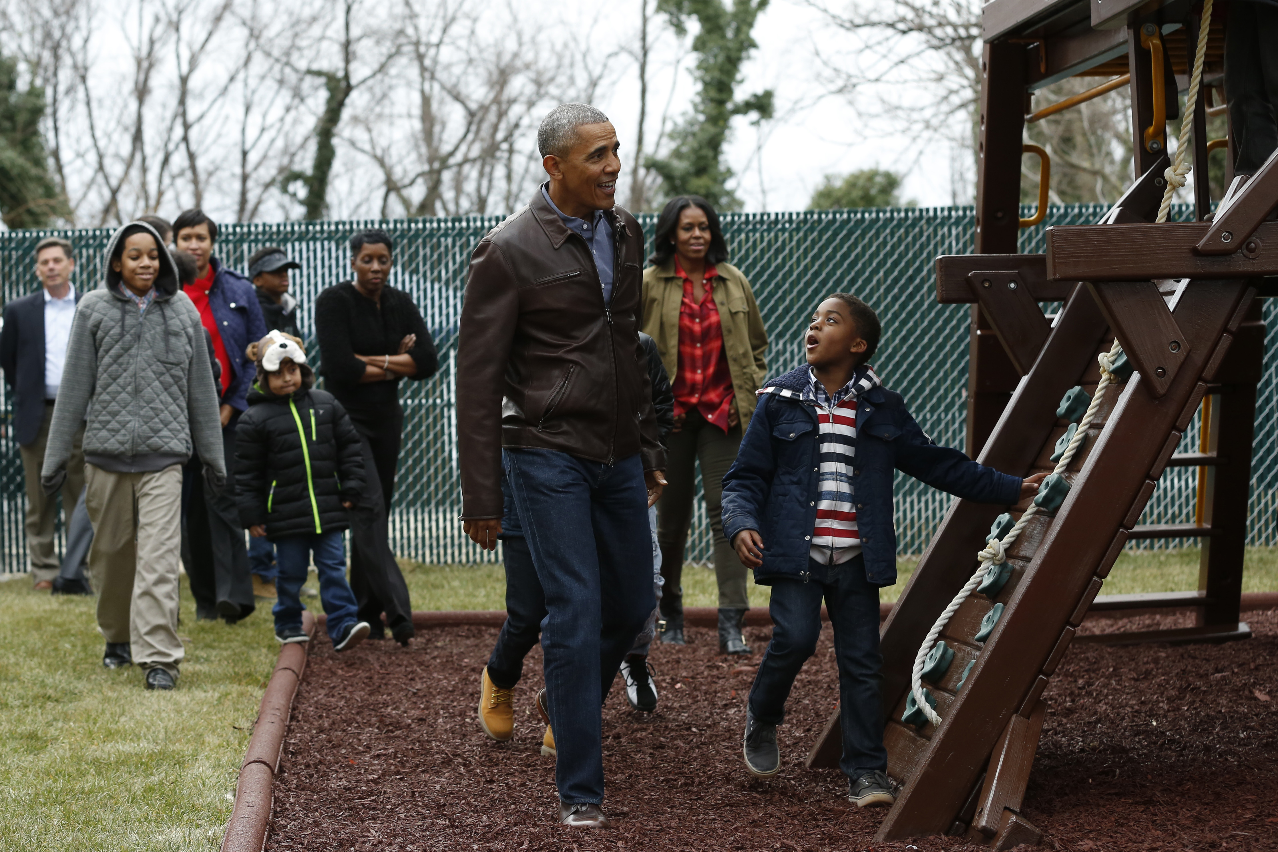 US President Barack Obama and First Lady Michelle Obama play with children on a swing donated by the first family at the Jobs Have Priority Shelter in Washington, DC on January 16, 2017. / AFP / YURI GRIPAS (Photo credit should read YURI GRIPAS/AFP/Getty Images) (YURI GRIPAS—AFP/Getty Images)