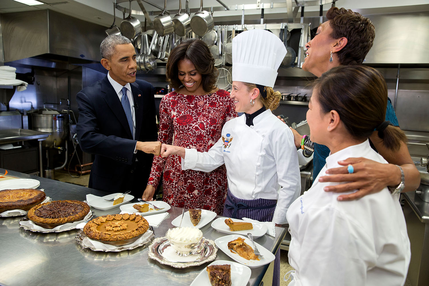 President Barack Obama fist bumps Executive Pastry Chef Susie Morrison after sampling pies with First Lady Michelle Obama, ABC News Anchor Robin Roberts and Executive Chef Cris Comerford during an interview about Thanksgiving in the White House Kitchen, Nov. 19, 2014. (Pete Souza—The White House)