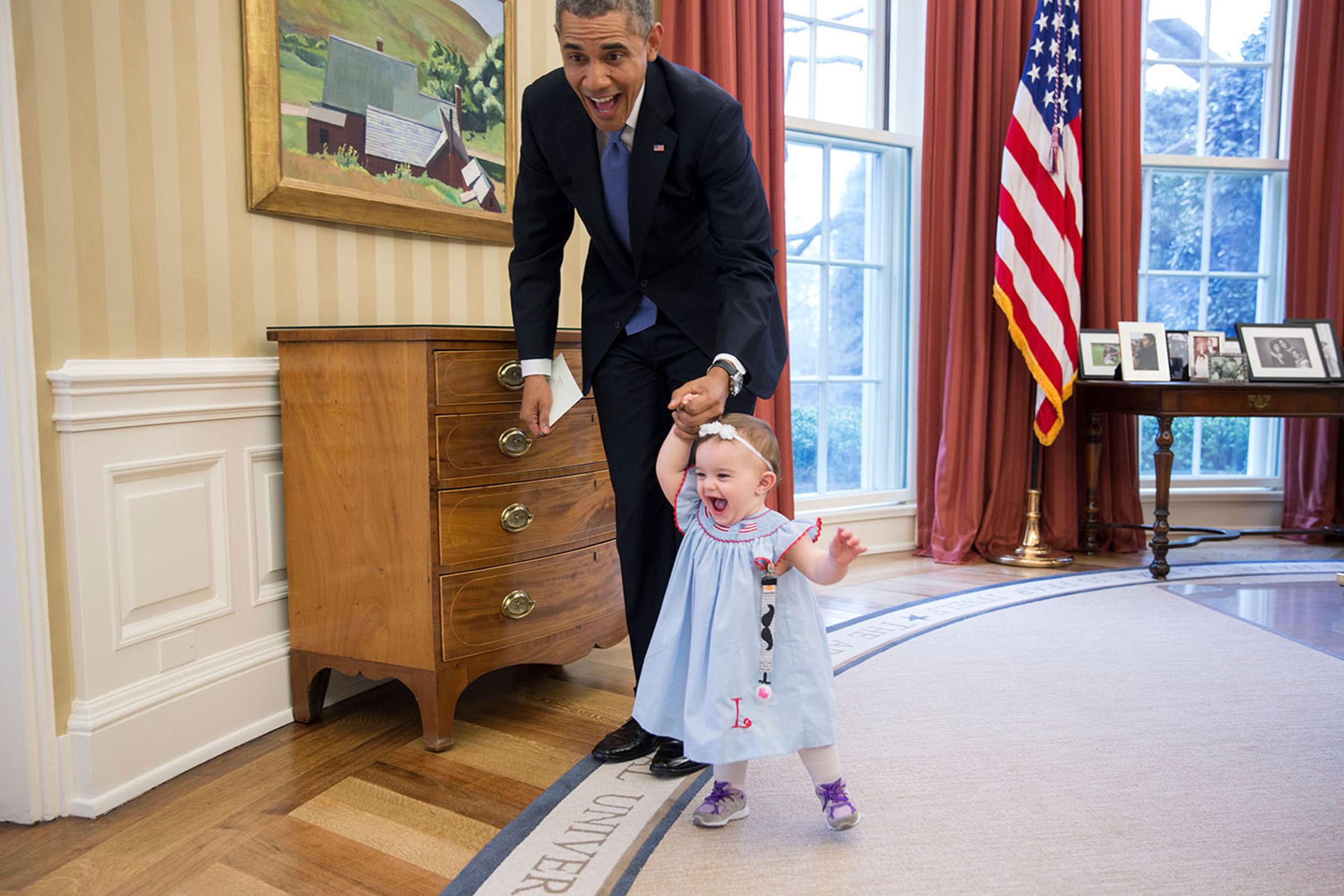 President Barack Obama walks with Lincoln Rose Pierce Smith, the daughter of former Deputy Press Secretary Jamie Smith, in the Oval Office, April 4, 2014. (Official White House Photo by Pete Souza)This official White House photograph is being made available only for publication by news organizations and/or for personal use printing by the subject(s) of the photograph. The photograph may not be manipulated in any way and may not be used in commercial or political materials, advertisements, emails, products, promotions that in any way suggests approval or endorsement of the President, the First Family, or the White House.