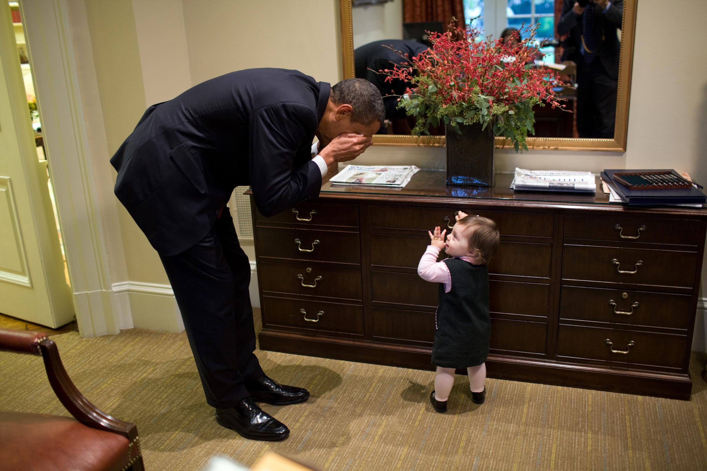 Oct. 30, 2009“The President plays peek-a-boo with the daughter of White House staffer Emmitt Beliveau in the Outer Oval Office. It’s interesting to note that this photograph was taken not long after the conclusion of his Afghanistan meeting in the Situation Room. So he went from this very substantive meeting to being able to lighten up for a minute with this young girl.”(Official White House photo by Pete Souza)This official White House photograph is being made available only for publication by news organizations and/or for personal use printing by the subject(s) of the photograph. The photograph may not be manipulated in any way and may not be used in commercial or political materials, advertisements, emails, products, promotions that in any way suggests approval or endorsement of the President, the First Family, or the White House.