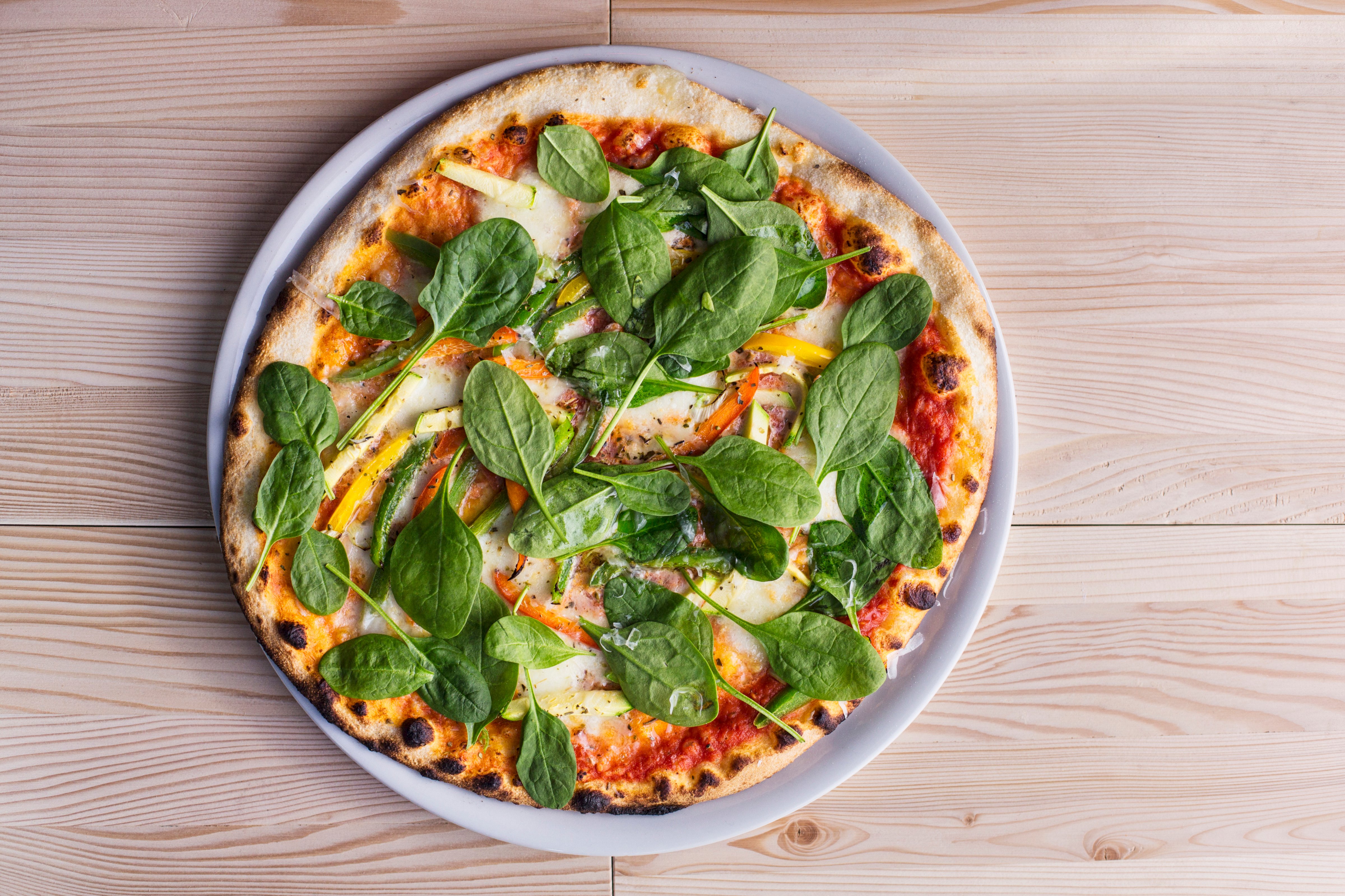 Vegetarian pizza with fresh baby spinach. (Lumina Images—Getty Images/Blend Images)