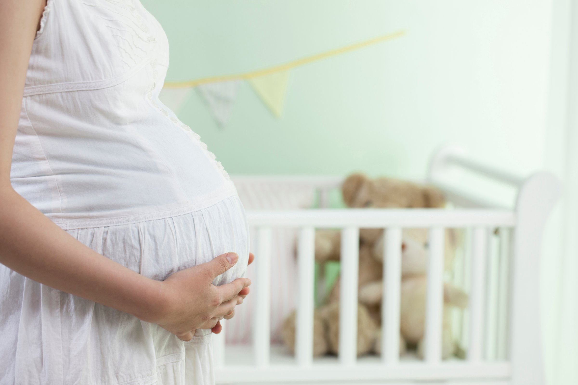 A pregnant woman in a baby room