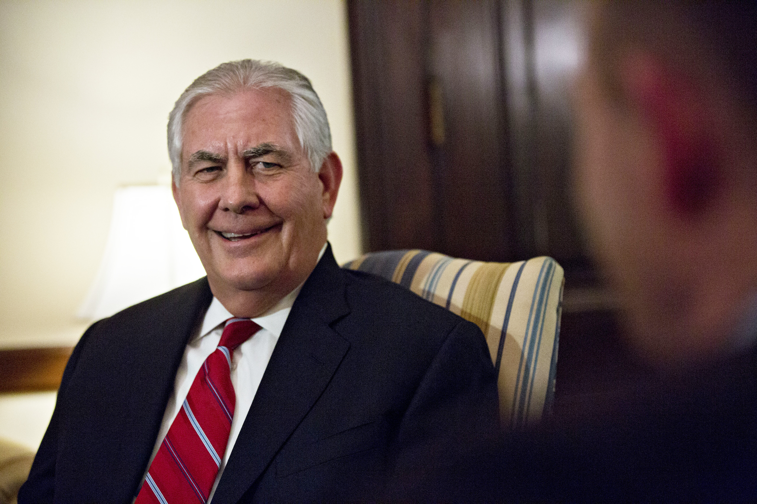 Rex Tillerson, the former chief executive officer of Exxon Mobile Corp. and U.S. secretary of state nominee for president-elect Donald Trump, smiles as he meets with Senator Christopher "Chris" Coons, a Democrat from Delaware, right, on Capitol Hill in Washington, D.C., on  Jan. 4, 2017. (Andrew Harrer—Bloomberg/Getty Images)
