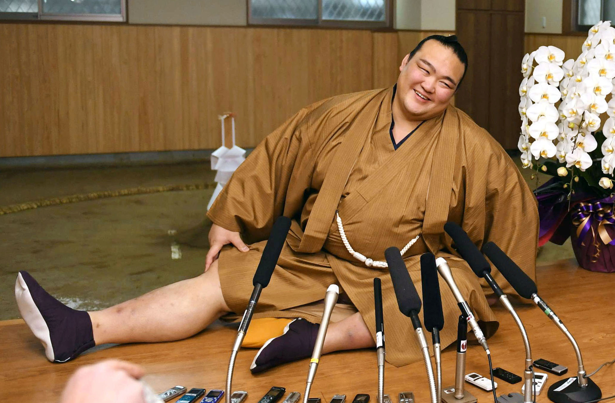 New Year Grand Sumo Tournament winner ozeki Kisenosato stretches his legs during a press conference at his Tagonoura stable in Tokyo