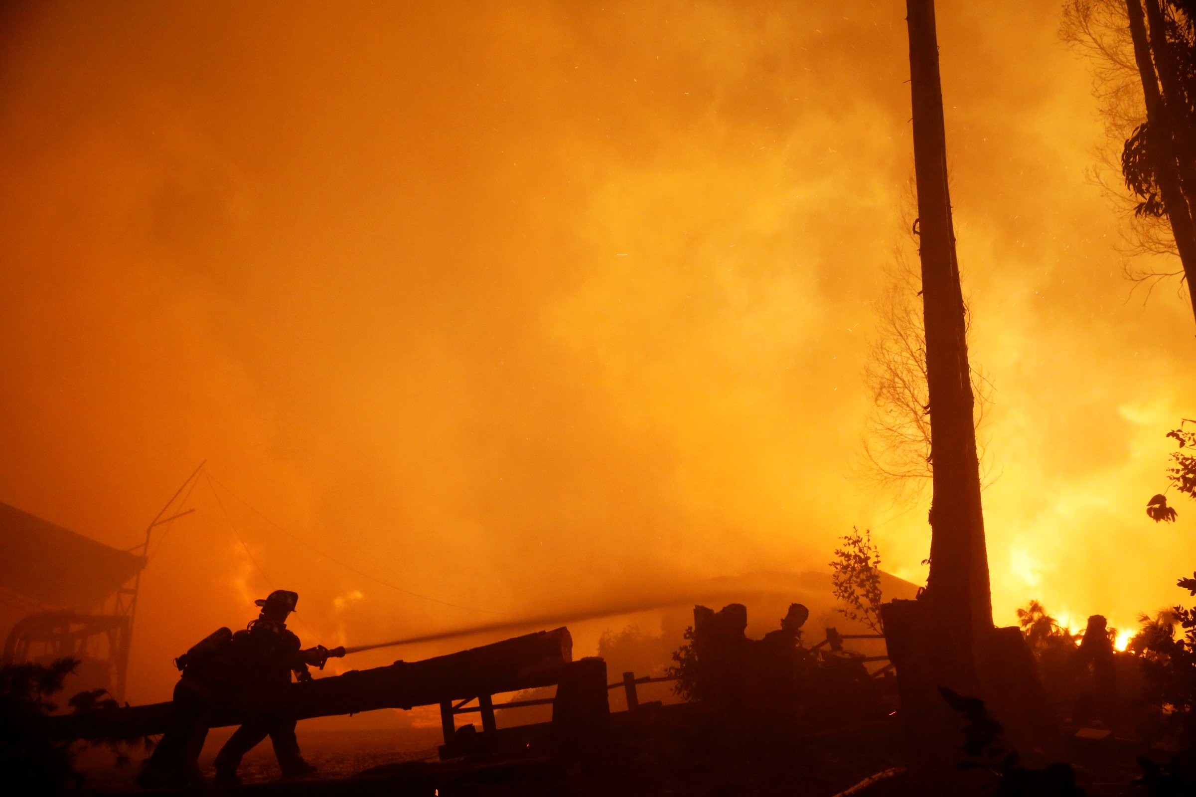 Firefighters try to stop a fire as the worst wildfires in Chile's modern history ravage wide swaths of the country's central-south regions