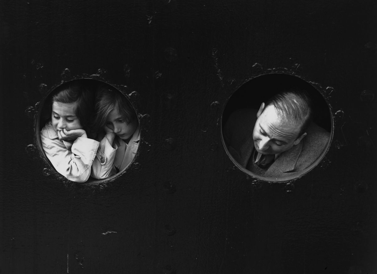 German Jewish refugees, looking through portholes aboard the Hamburg-Amerika liner 'St Louis' on arrival at Antwerp. June 17, 1939. (Gerry Cranham—Getty Images)