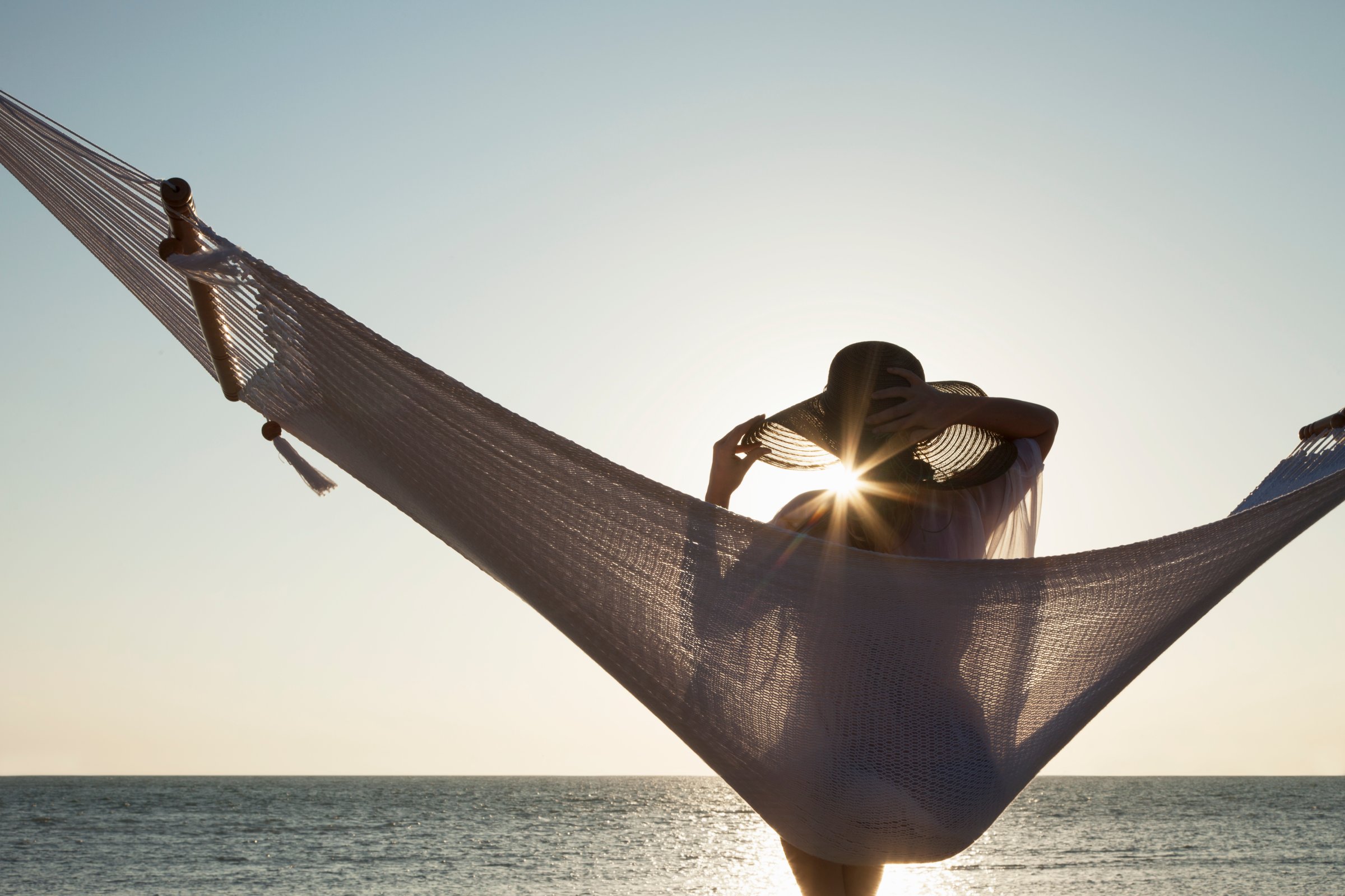 Woman relaxing in a hammock on the beach